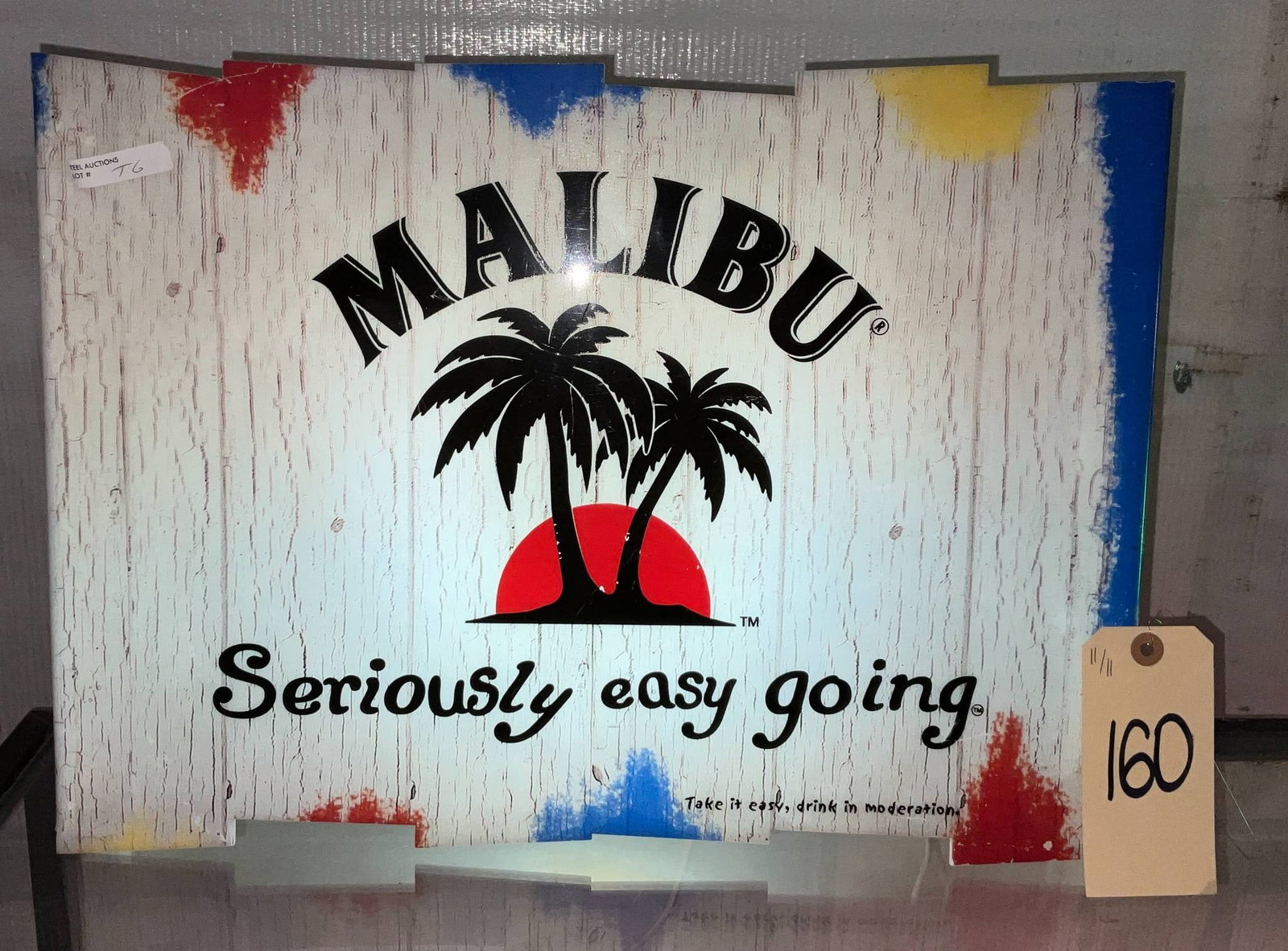 Malibu Advertising Light with Tropical Design, 14 x 19 Inches: Working Malibu advertising light featuring a tropical-themed design with palm trees over a red sun and text reading 'Seriously easy going.' Measures 14 x 19 inches tall. Designed for promotional displ
