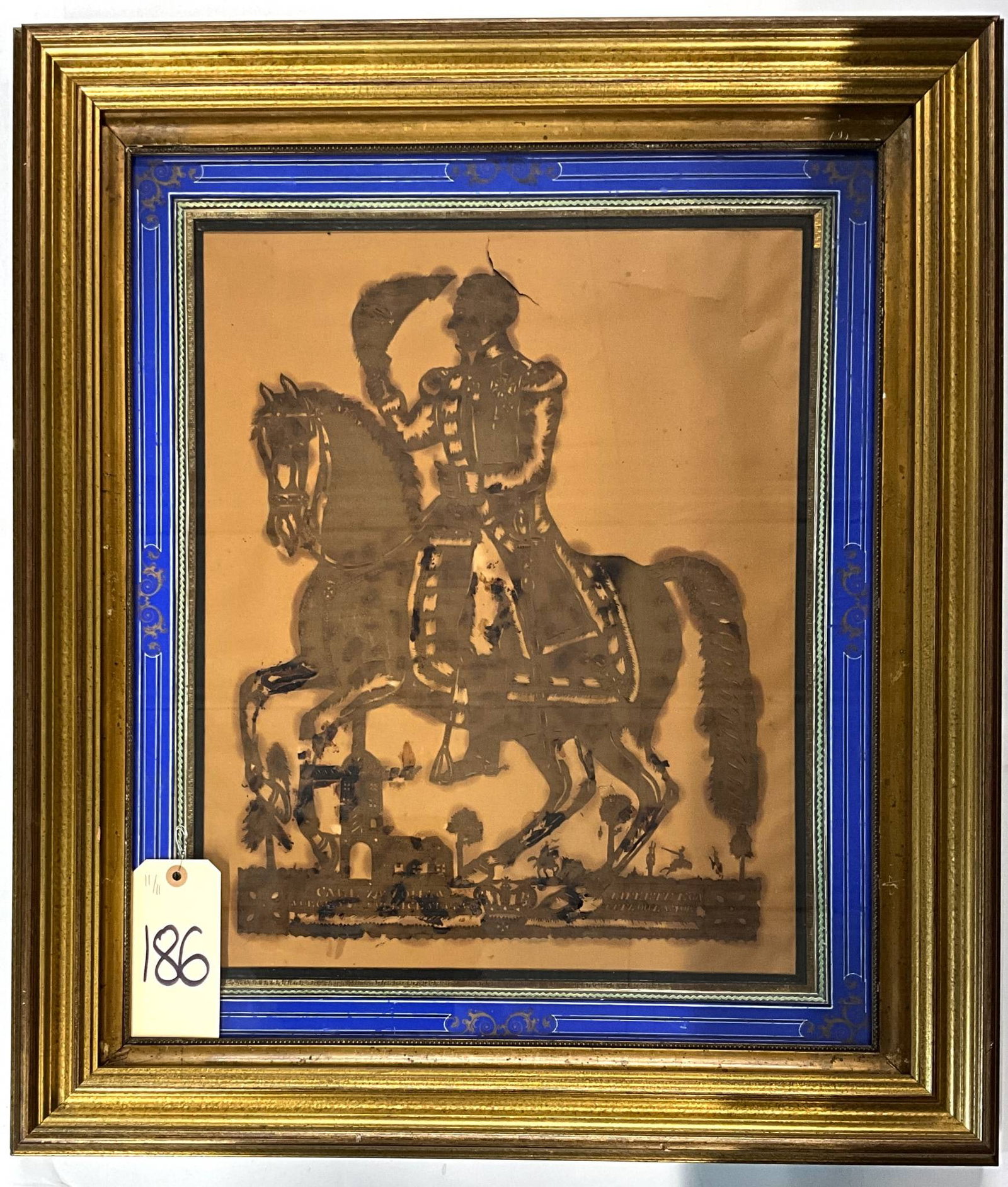 Vintage Scherenschnitte Depicting a Mounted Figure in a Vintage Frame, 26 x 30 Inches: Scherenschnitte artwork depicting a mounted figure, likely historical or military in nature, featuring a detailed background with architectural and natural elements. Inscribed text in the lower portio