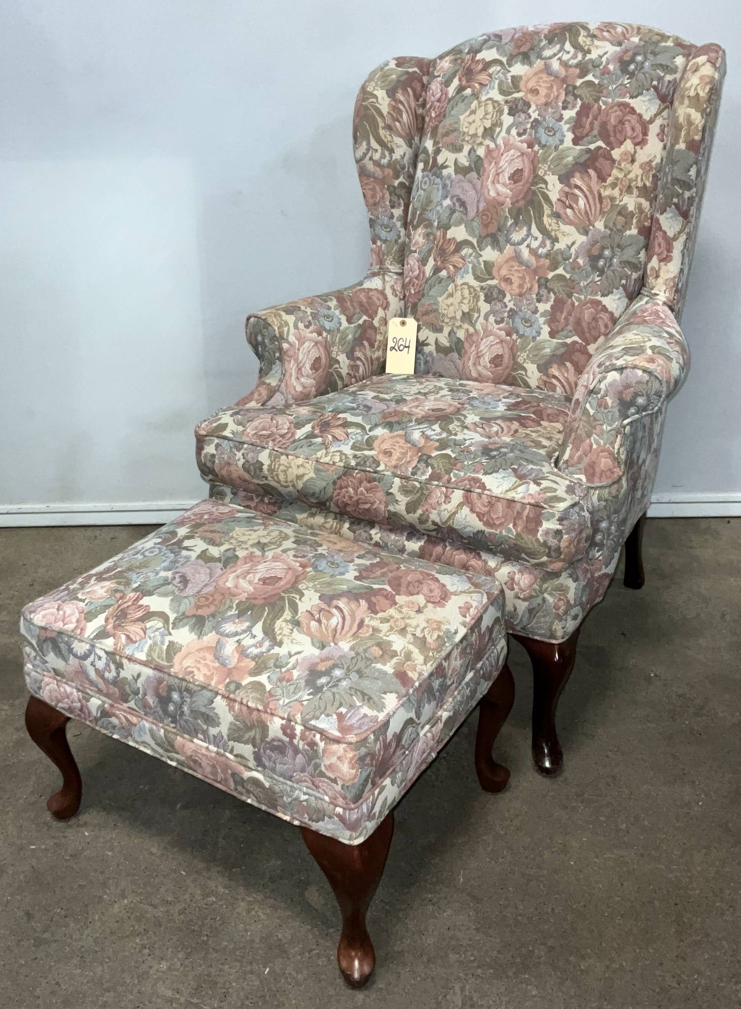 Wingback Armchair and Ottoman with Floral Upholstery: Wingback armchair and ottoman set featuring floral-patterned upholstery. The armchair measures 32 inches wide, 45 inches high, and 20 inches from floor to seat. The ottoman measures 24 by 18 inches an