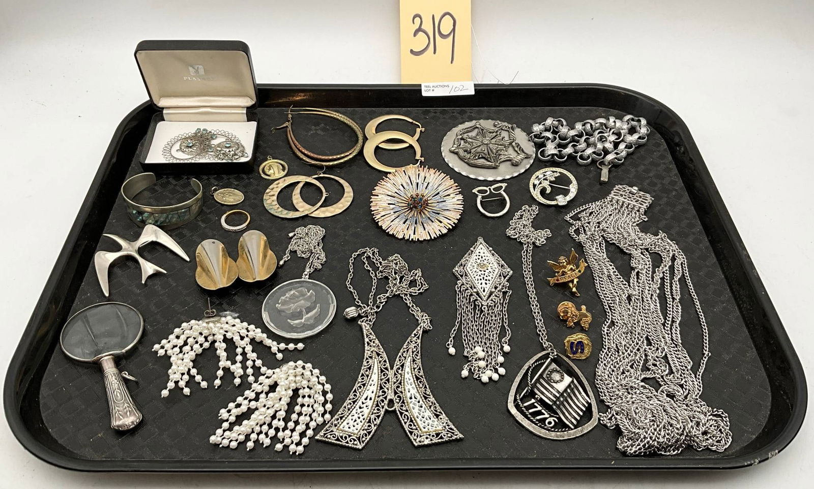 Jewelry Tray Lot Featuring Silver, Gold-Tone, and Costume Pieces: A jewelry tray lot consisting of diverse items such as silver and gold-tone bracelets, necklaces, earrings, brooches, and pendants. Highlights include a magnifying glass with an ornate handle, filigre
