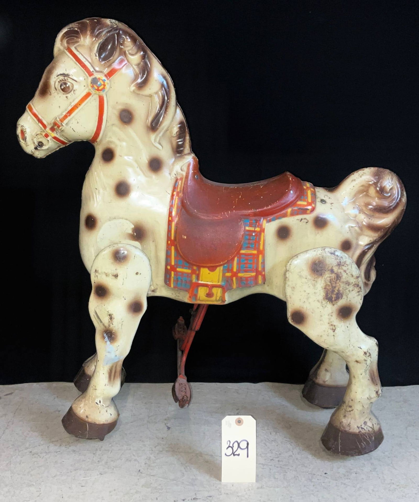 Vintage Carousel-Style Rocking Horse, 27 to 30 Inches High: Vintage carousel-style rocking horse, measuring between 27 and 30 inches high. Features a dappled horse design with spots, a red saddle, and plaid blanket detailing on the sides. Likely designed for c