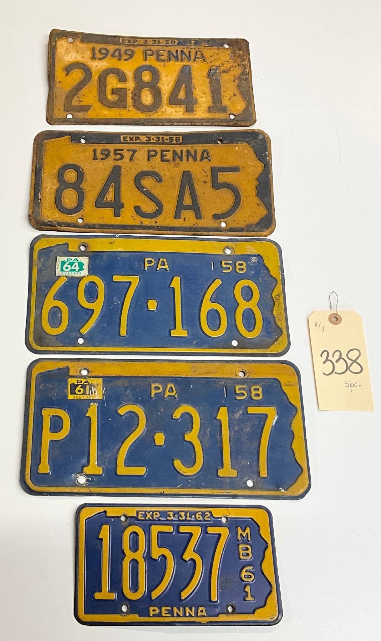 5 Vintage Pennsylvania License Plates, 1945-1961: Five vintage Pennsylvania license plates, including examples from 1945, 1957, 1958, and 1961. Each plate displays its original printed number and reflects the design and typography of its respective y