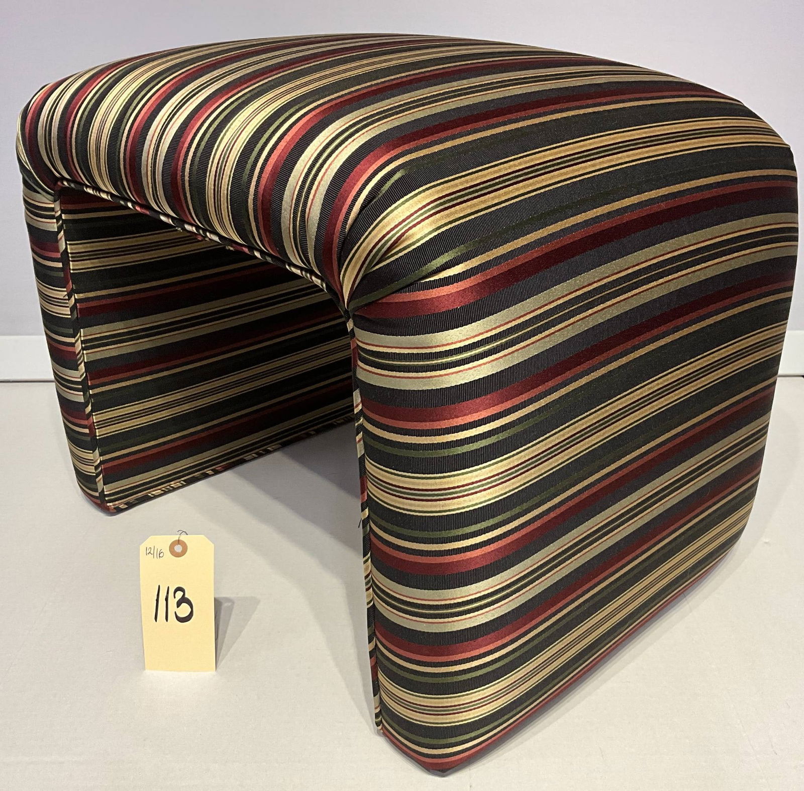 Postmodern Waterfall Stool in Karl Springer Style with Striped Upholstery: Waterfall-style stool measuring 23 inches by 19 inches and 18 inches high, reminiscent of Karl Springer’s postmodern designs. Constructed with a bent-form frame, upholstered in a striped fabric feat