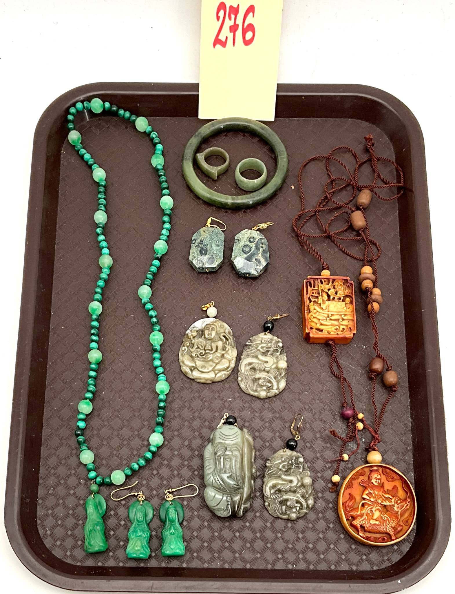 Malachite, Jade, and Bone Necklaces, Pendants, Earrings, and Bangle Jewelry Assortment: Jewelry items including necklaces, pendants, earrings, and bangles crafted using malachite, jade, and bone. Includes a beaded malachite necklace with matching figure-shaped earrings, carved jade penda