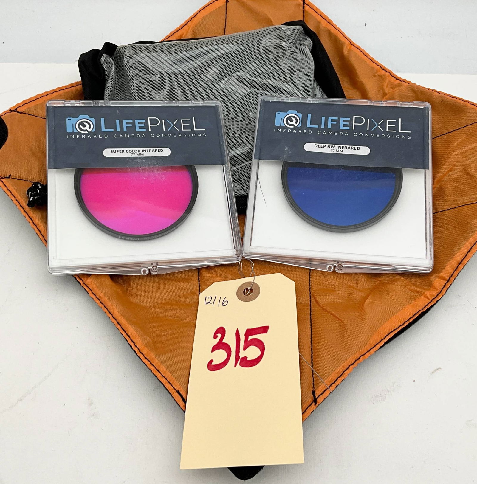 LifePixel Daylight IR and Ultra Blue Infrared Camera Filters with Orange and Gray Photography: A LifePixel Daylight IR photography filter and a LifePixel Ultra Blue infrared filter housed in individual plastic cases. Filters designed for specialized photographic effects. Accompanied by an orang
