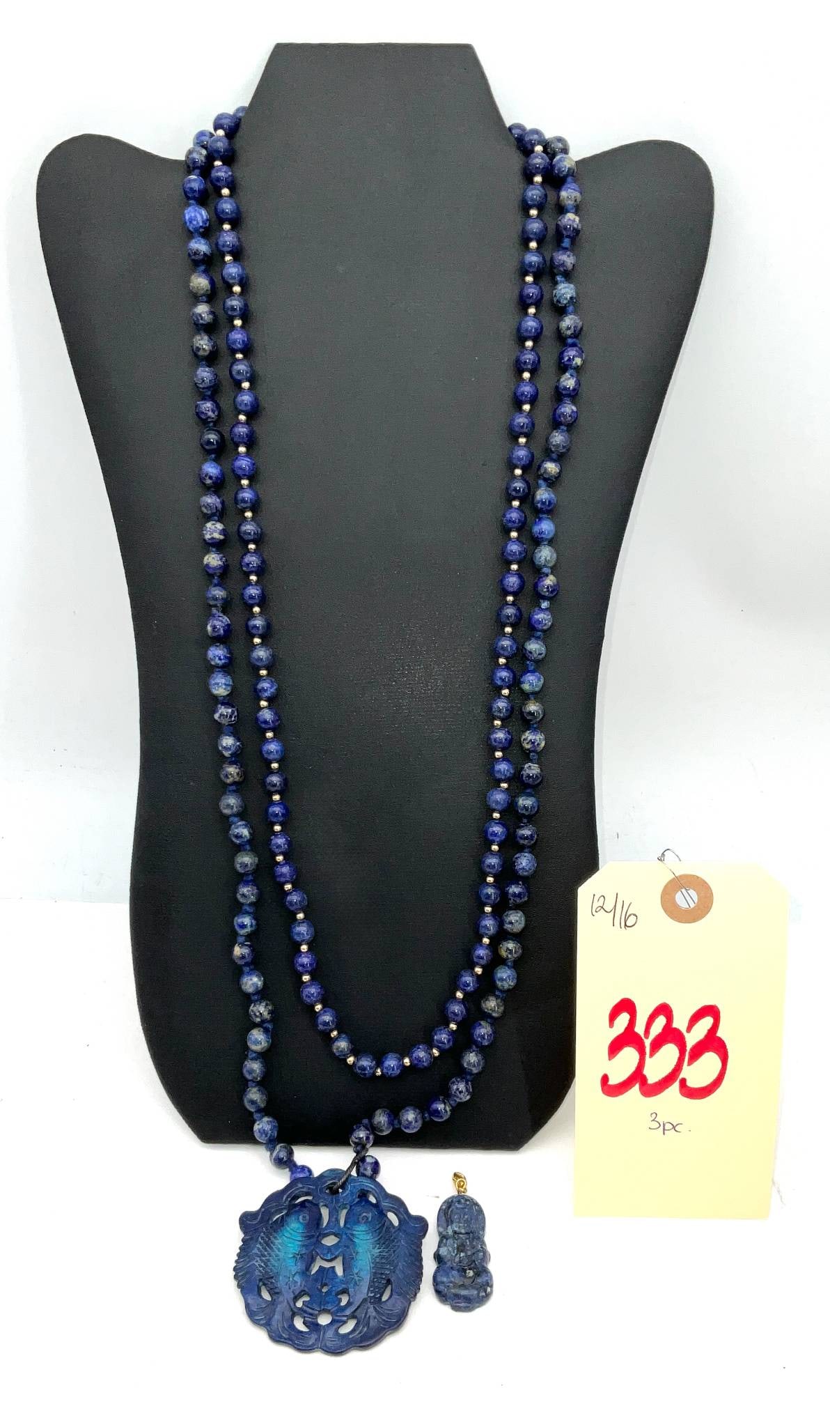 Asian Carved Lapis Lazuli Necklace With Fish Motif Pendant and Additional Figurine Pendant: Necklace featuring polished lapis lazuli beads strung with gold-tone spacer elements, culminating in a carved lapis lazuli fish motif pendant. Includes an additional carved lapis lazuli figurine penda