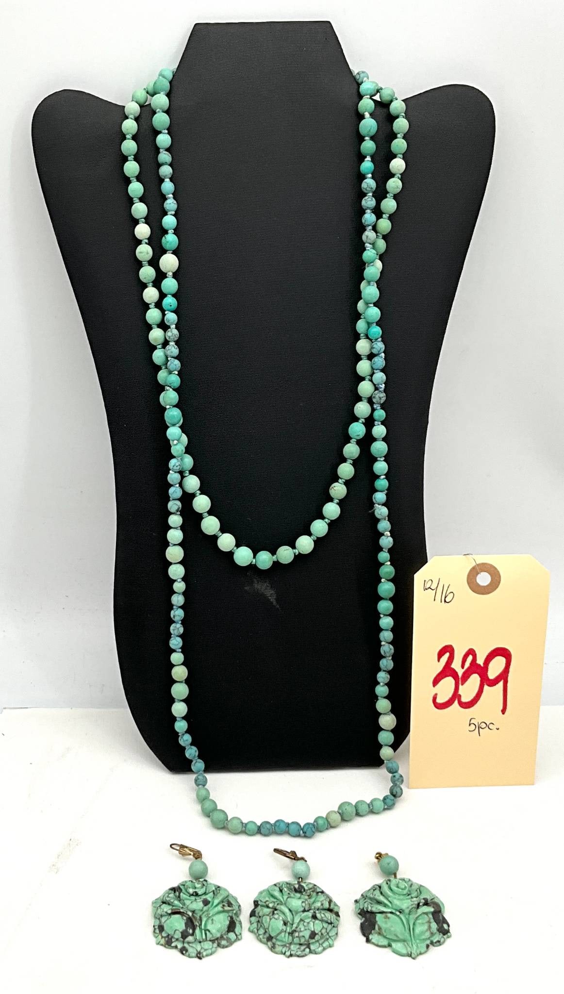 Hand-Carved Turquoise Jewelry Set Featuring Necklace, Earrings, and Pendant: Jewelry set including a hand-carved turquoise bead necklace approximately 28 inches long, featuring a gold-plated clasp marked 'Silver.' Also includes one pair of clip-on earrings with hand-carved flo
