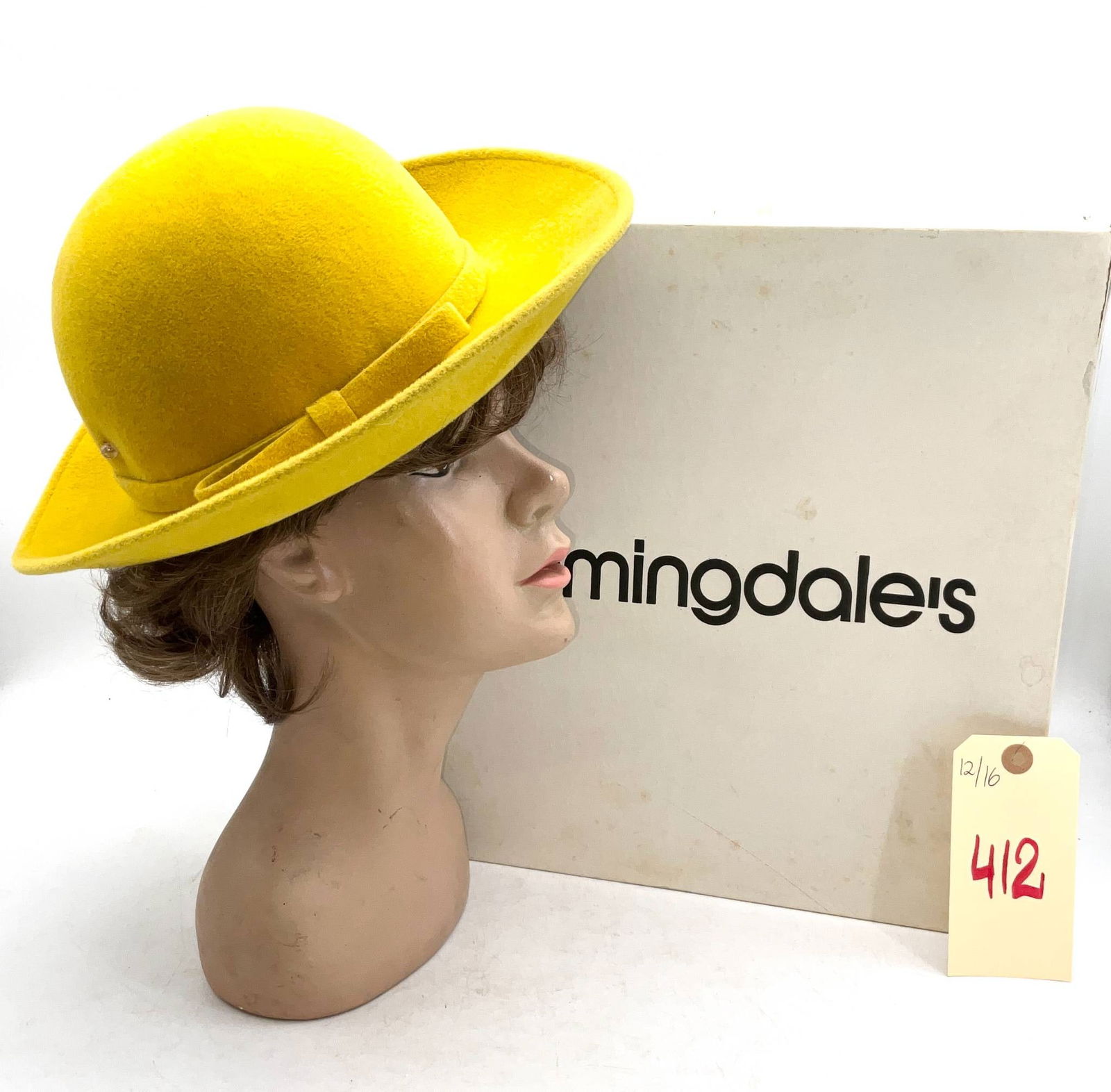 Vintage Italian-Made Bloomingdale’s Hat with Box: Vintage Italian-made yellow hat sold by Bloomingdale's. This hat showcases vibrant yellow fabric construction, featuring a ribbon detail circling the crown. The inner lining includes a sewn-in tag pri