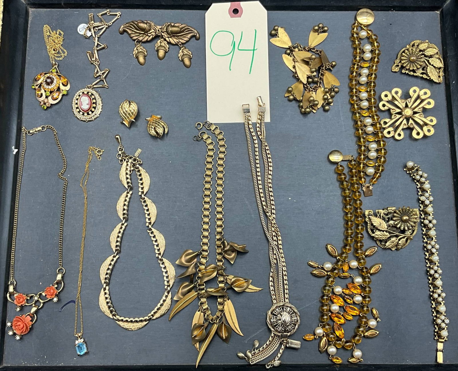 Gold-Toned Jewelry Featuring Monet, Coro, and Zentall Pieces: Gold-toned jewelry, including necklaces, brooches, earrings, and bracelets. Notable makers include Monet, Coro, and Zentall, each marked on select items. Pieces include floral and leaf motifs, detaile