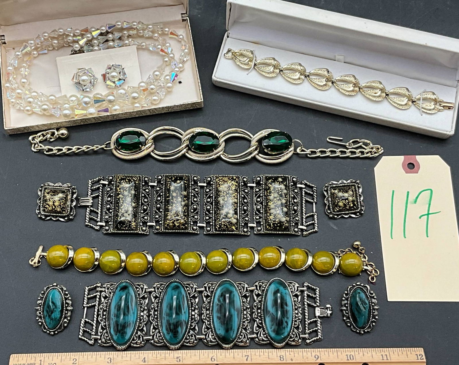 Coro and Assorted Costume Jewelry: Costume jewelry attributed to Coro and other makers, featuring signature elements of mid-century design. Includes bracelets with faux gem inlays (green, yellow, and blue tones), a gold-tone leaf-motif