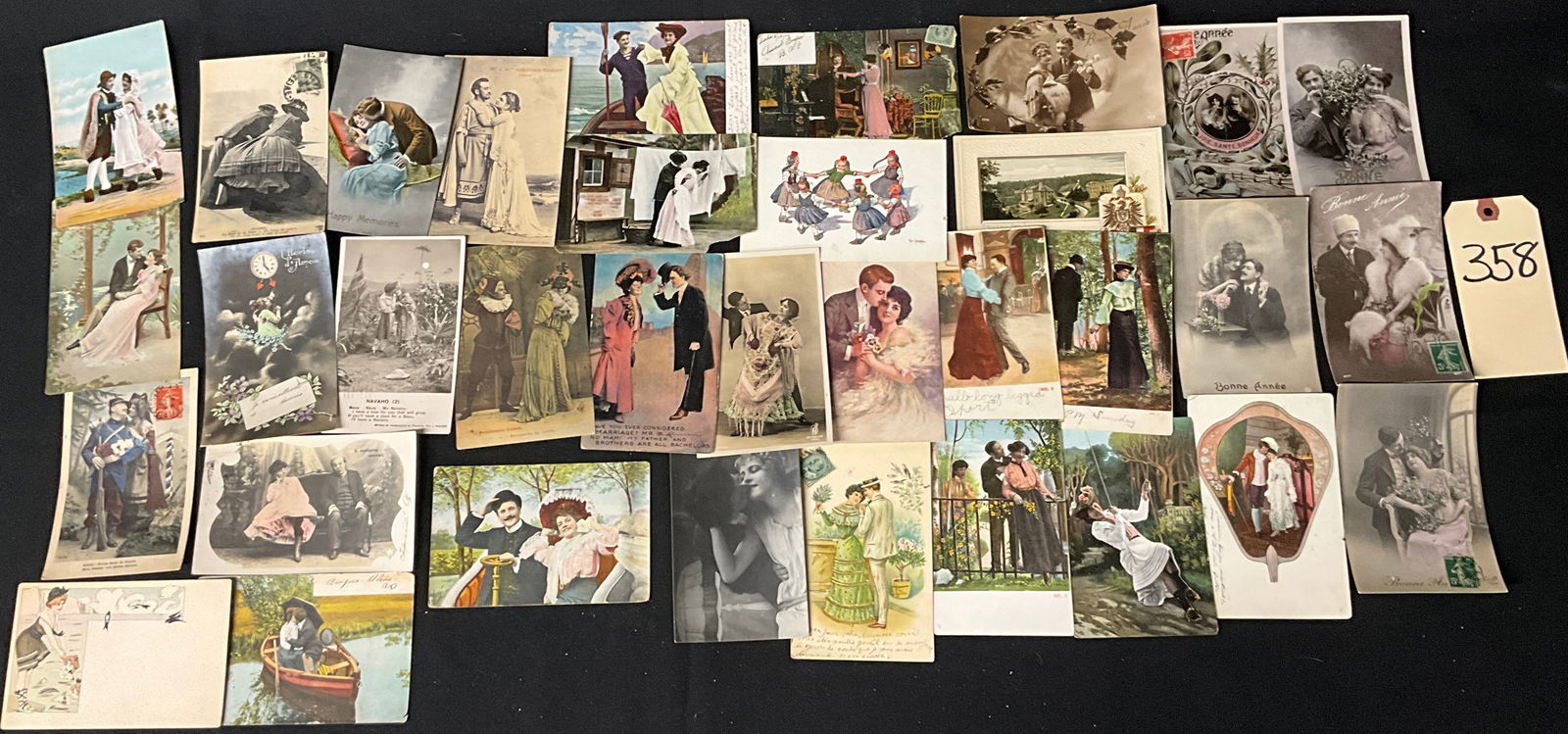 Romantic and Sentimental Antique Postcards: This lot features antique postcards, including real photo and hand-tinted printed examples, centered on Belle Epoque and Edwardian romantic themes. The collection includes Bonne Annee greetings and