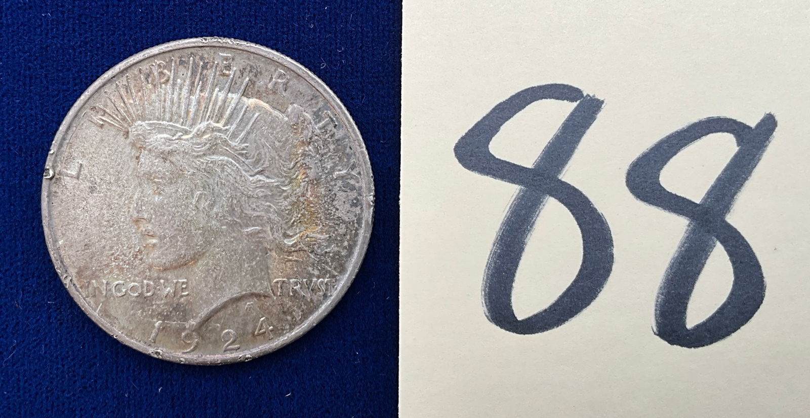 US 1924 Peace Dollar, Silver: Peace Dollar. Designer: Anthony de Francisci. This type of coin was struck at the Philadelphia Mint, identified by the lack of a mint mark. The silver composition consists of 90 percent silver and 10