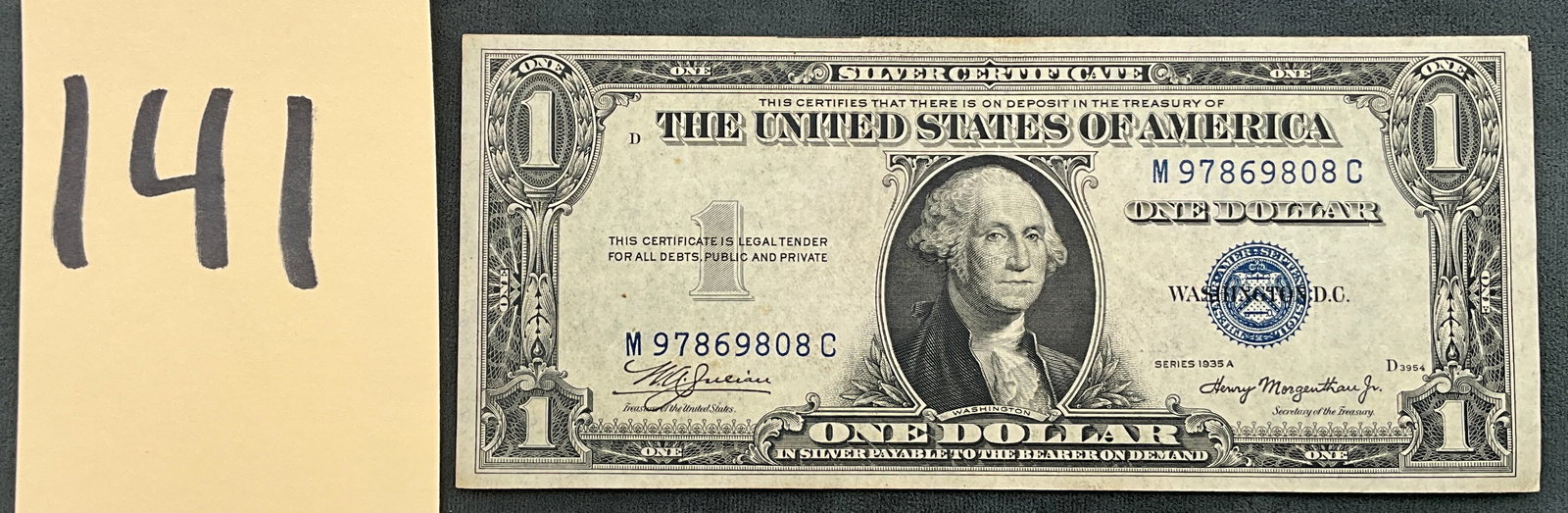 US 1935 A $1 Silver Certificate, Fr. 1608: Friedberg 1608. Signatures of W.A. Julian and Henry Morgenthau Jr. Blue Treasury seal and serial numbers M 97869808 C. Obverse plate D3954; reverse plate 3227. This type of silver certificate was