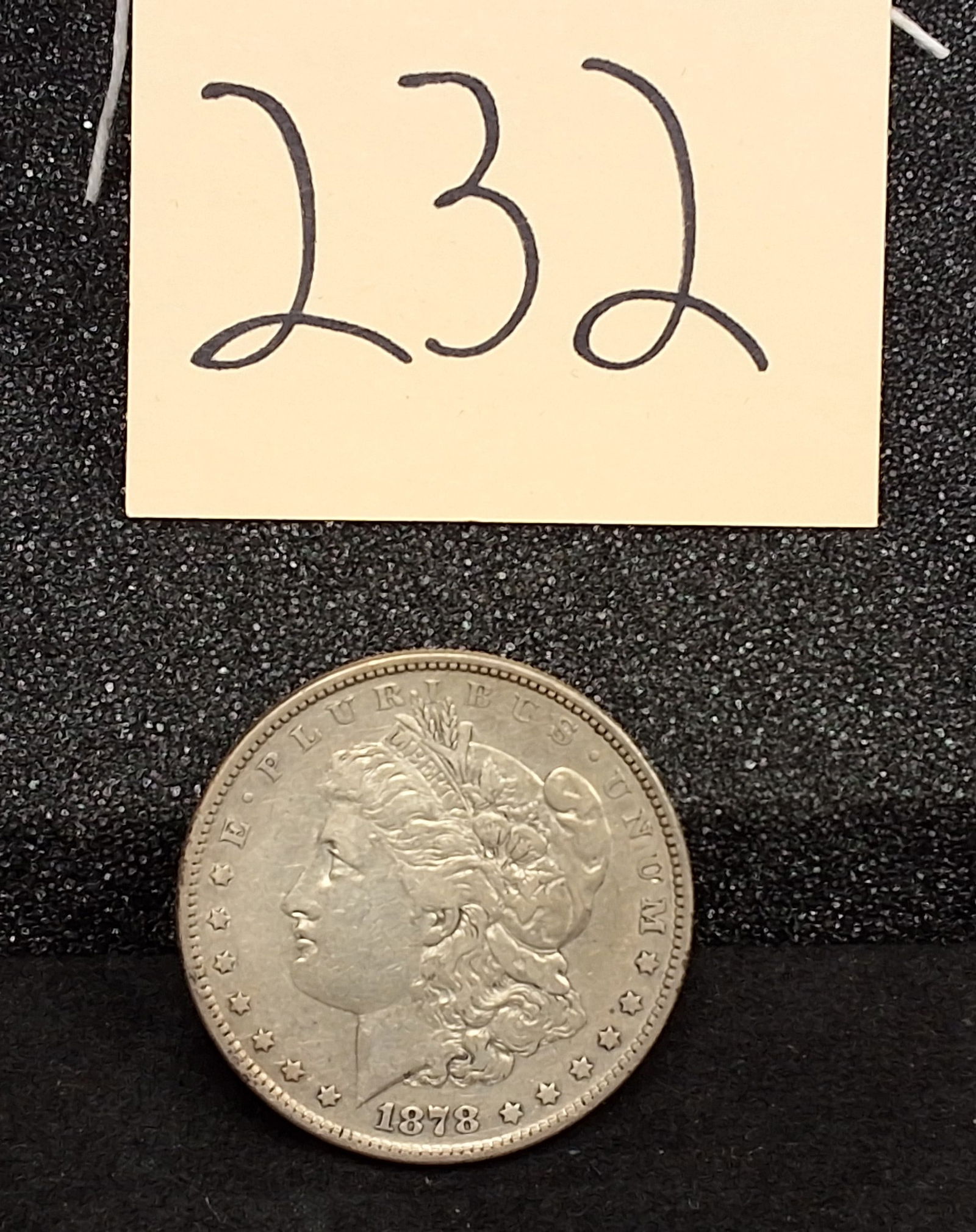US 1878 Morgan Dollar, Silver, KM-110: KM-110. Designer: George T. Morgan. Philadelphia Mint. Liberty Head / Eagle reverse. Seven tail feathers variety. This issue represents the first year of production for the series following the passag