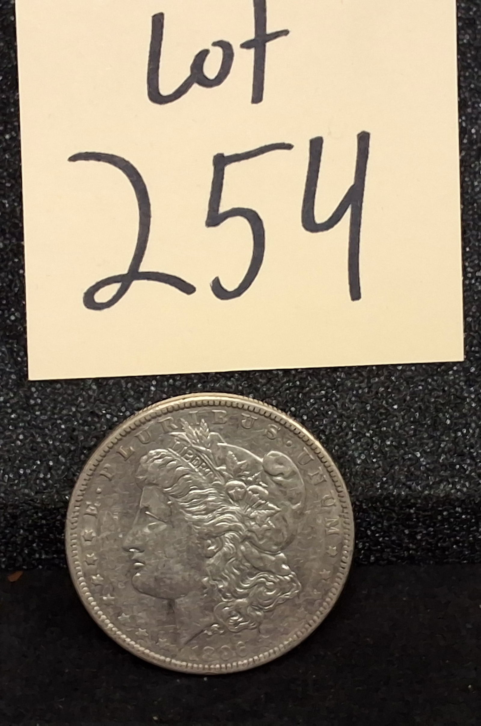 US 1896-O Morgan Dollar, Silver, KM-110: KM-110. Designer: George T. Morgan. Mint mark O, New Orleans. Liberty Head / Eagle. The 1896-O issue had a mintage of 4,900,000 and is historically noted for frequently exhibiting a strike of lower