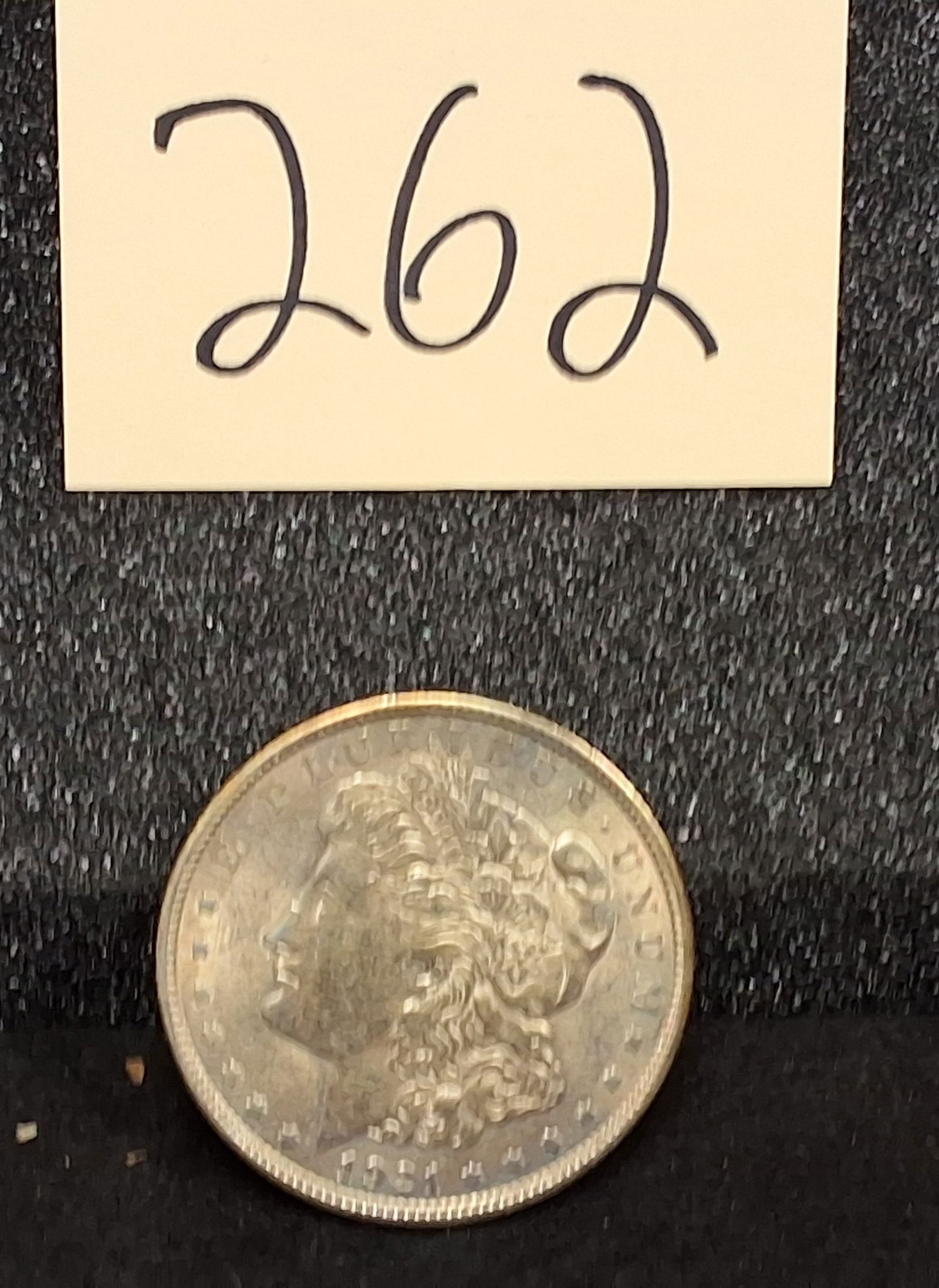 US 1921 Morgan Dollar, Silver, KM-110: Catalog number: KM-110. Designer: George T. Morgan. Mint mark: None (Philadelphia Mint). Design type: Morgan obverse / Eagle reverse. Key identifier: Inventory tag 262 included. The 1921 production