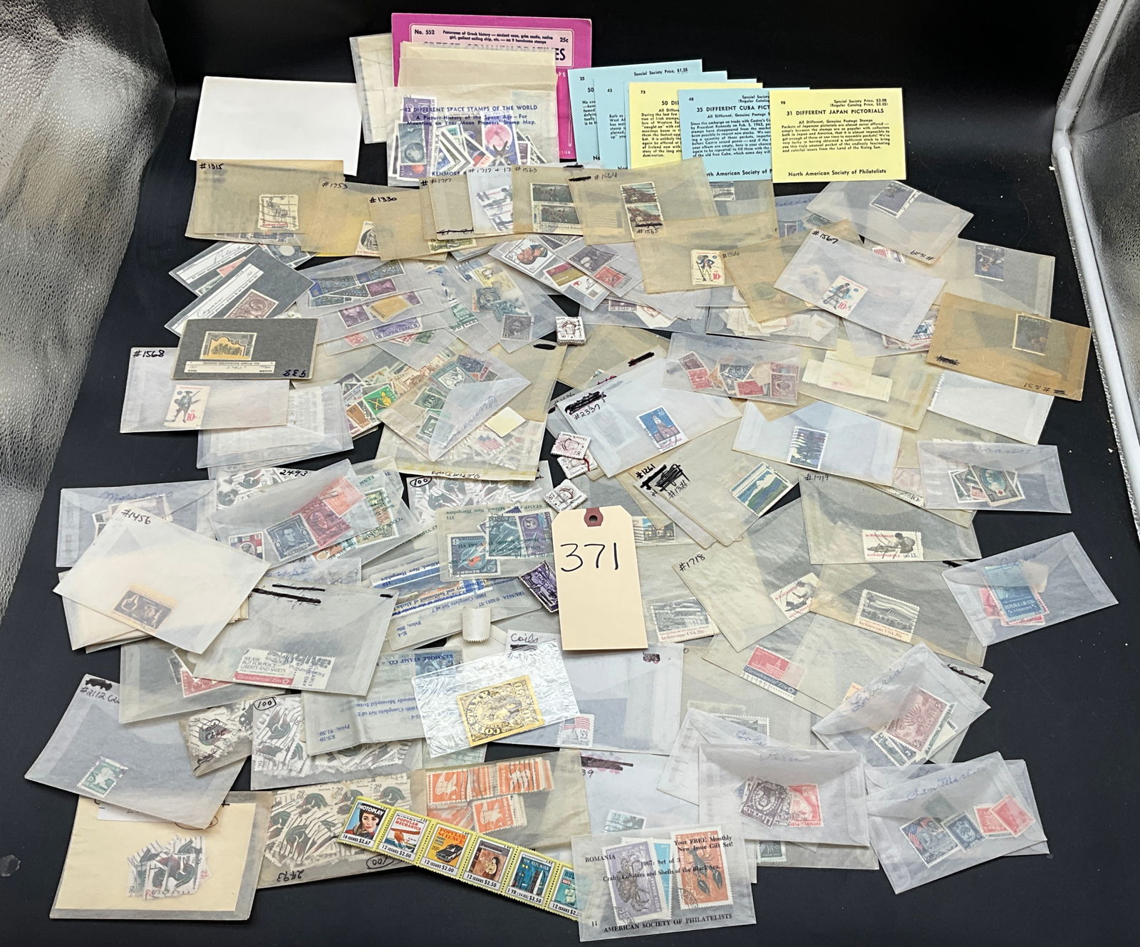 A Lot of Worldwide Stamps, US, RU, PL, and Others, Mixed Issues: This lot comprises a diverse collection of worldwide postage stamps from issuers including the US, Russia (CCCP), Poland, Grenada, and Japan. The assembly includes commemorative sets, space exploratio