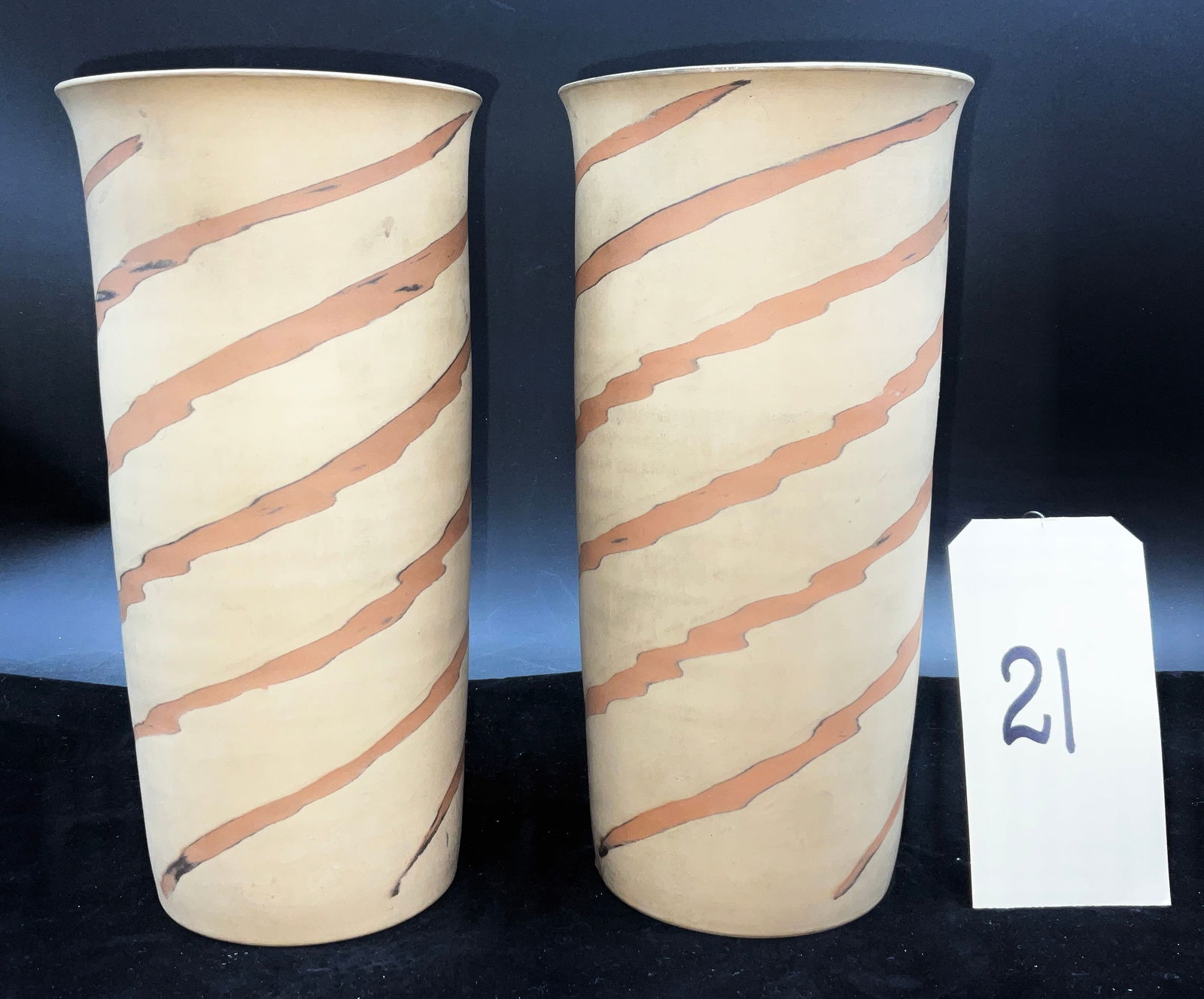Pair of Occupied Japan Mission Swirl Style Earthenware Vases: This pair of cylindrical earthenware vases features a tapering form with slightly flared rims, crafted in a matte, unglazed cream-colored body. The vessels are decorated with a hand-painted pattern of