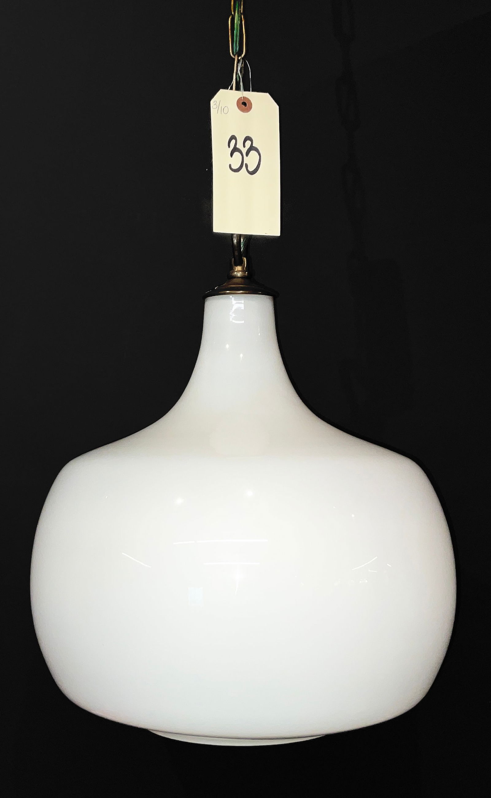 Venini Murano Mid-Century Modern White Cased Glass Pendant Lamp: This Mid-Century Modern pendant lamp features a large teardrop-shaped shade crafted from white cased glass, suspended by brass-toned metal hardware and a link chain. Manufactured by Venini of Murano,