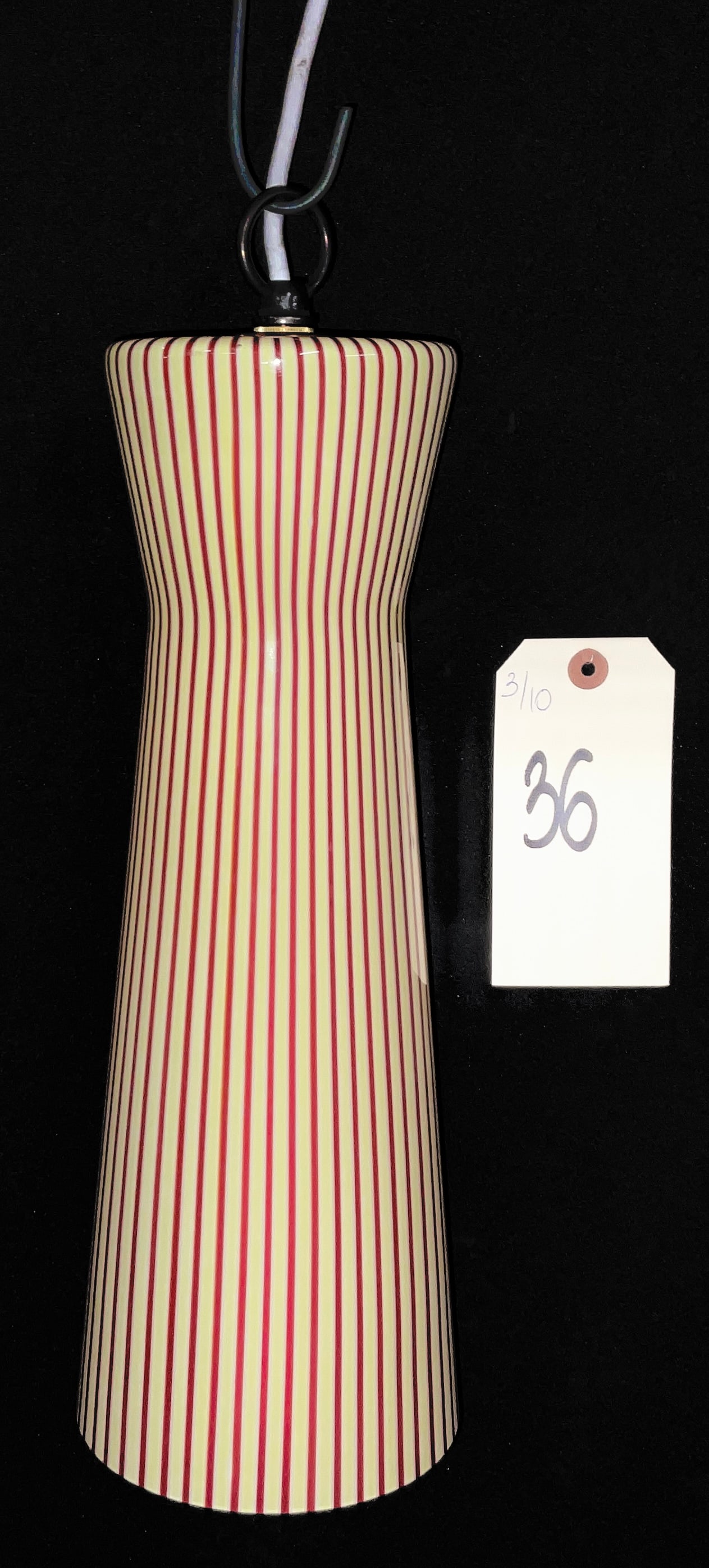 Italian Mid-Century Modern Murano Style Filigrana Glass Pendant Lamp: This Mid-Century Modern pendant lamp features an elongated, tapered cylindrical shade crafted from cased glass. The design showcases a pale cream ground accented by closely spaced vertical red stripes