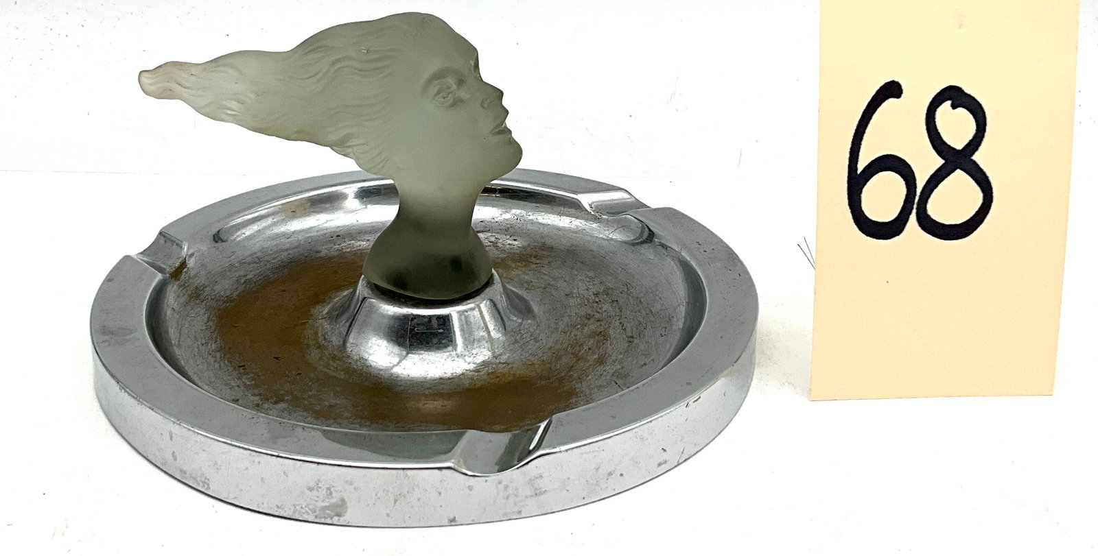 Lady Nicotine Art Deco Chrome and Satin Glass Ashtray: This Art Deco Lady Nicotine ashtray features a central frosted satin glass finial molded in the form of a stylized female head with flowing hair. The circular chrome-plated metal base is designed with