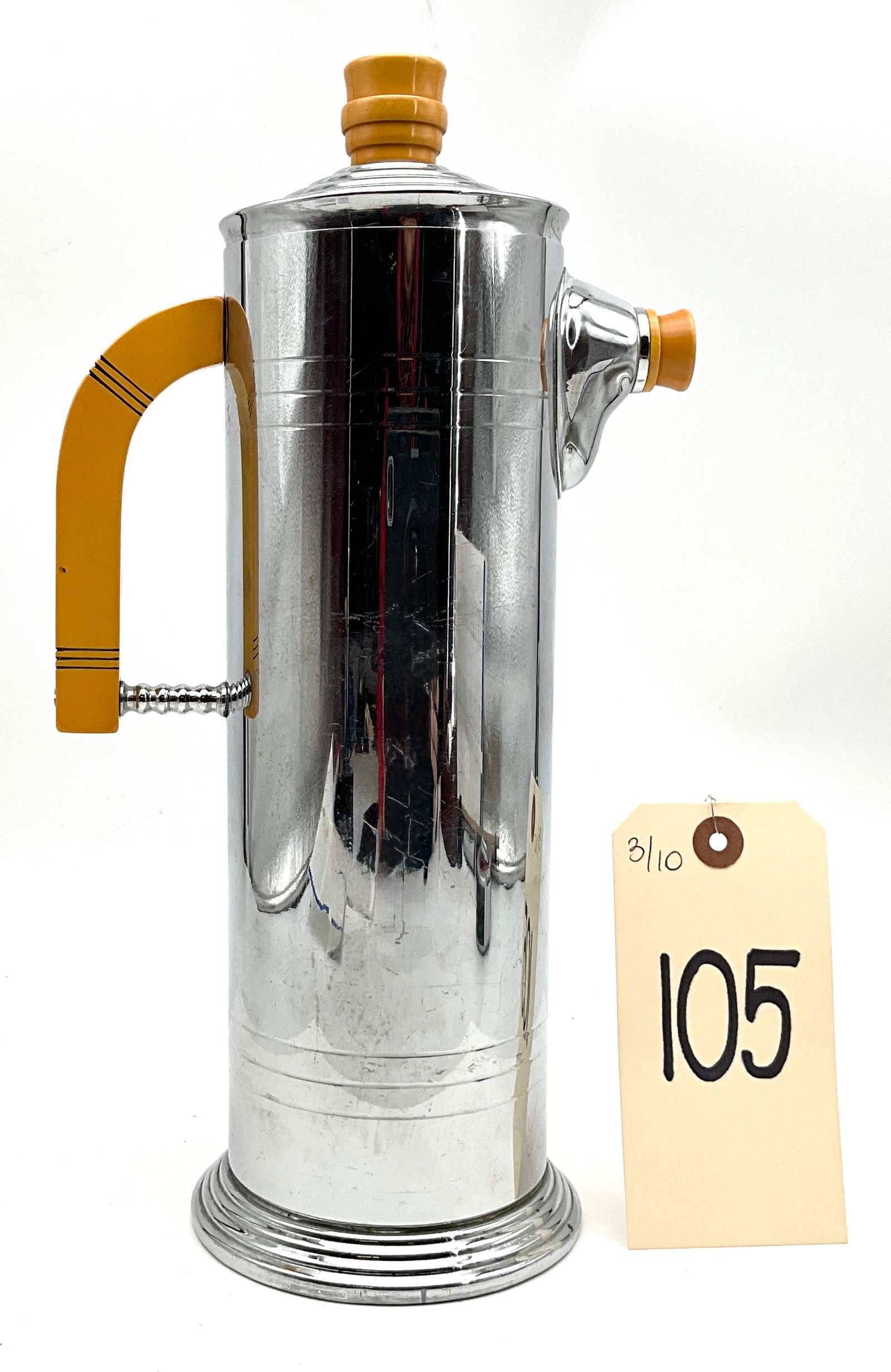 Lehman Brothers Art Deco Chromium Cocktail Shaker with Bakelite Accents: This tall, cylindrical cocktail shaker was manufactured by Lehman Brothers during the Art Deco era, circa 1930s-1940s. The piece is constructed from chromium-plated metal and features a distinctive bu