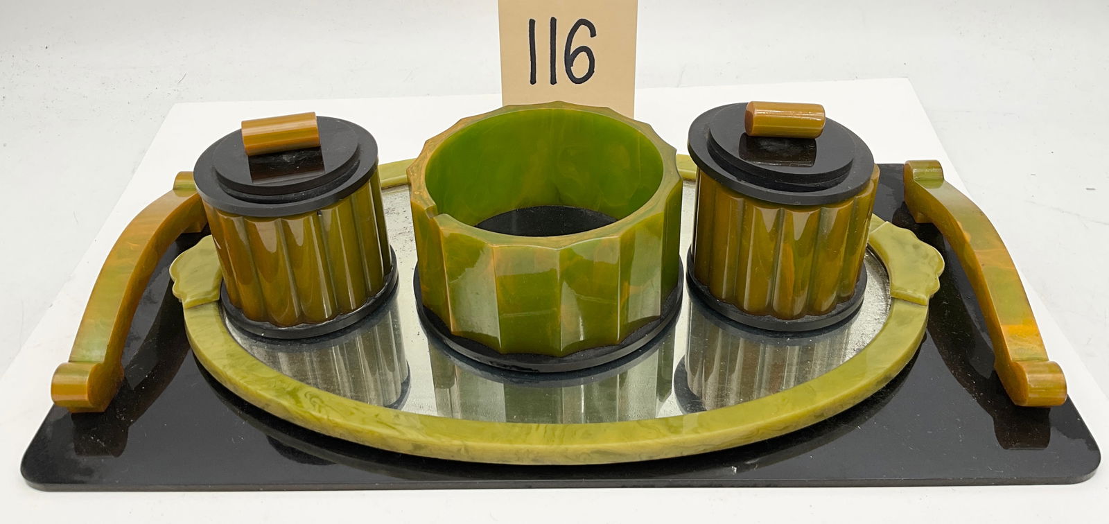 Art Deco Marbled Bakelite Vanity and Smoking Set: This Art Deco vanity or smoking set is crafted from marbled green and butterscotch Bakelite featuring characteristic geometric fluting and black accents. The set includes a large rectangular tray with