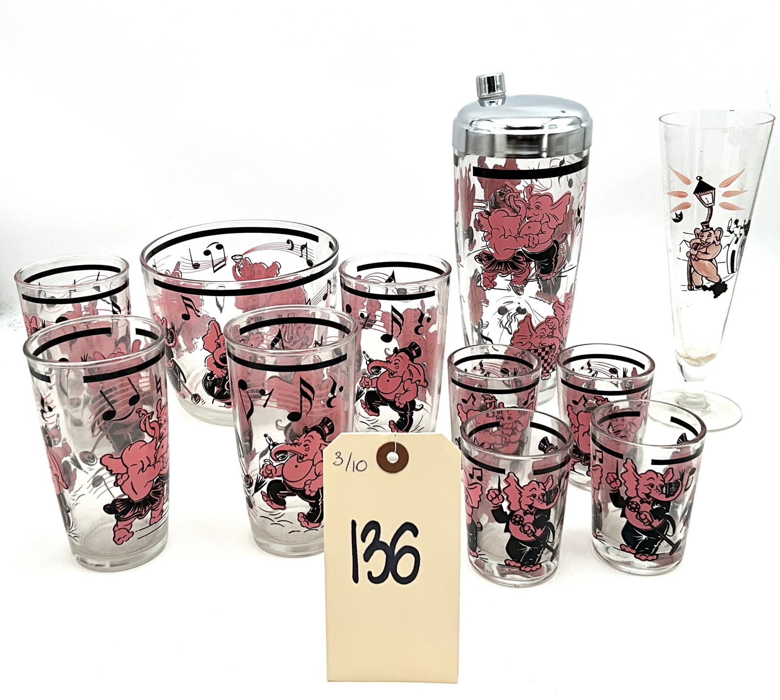 Libbey Glass Company Mid-Century Modern Pink Elephant Barware Set: This Mid-Century Modern barware collection by Libbey Glass Company features the whimsical Pink Elephant motif across a variety of clear pressed glass vessels. The set includes a cocktail shaker with a