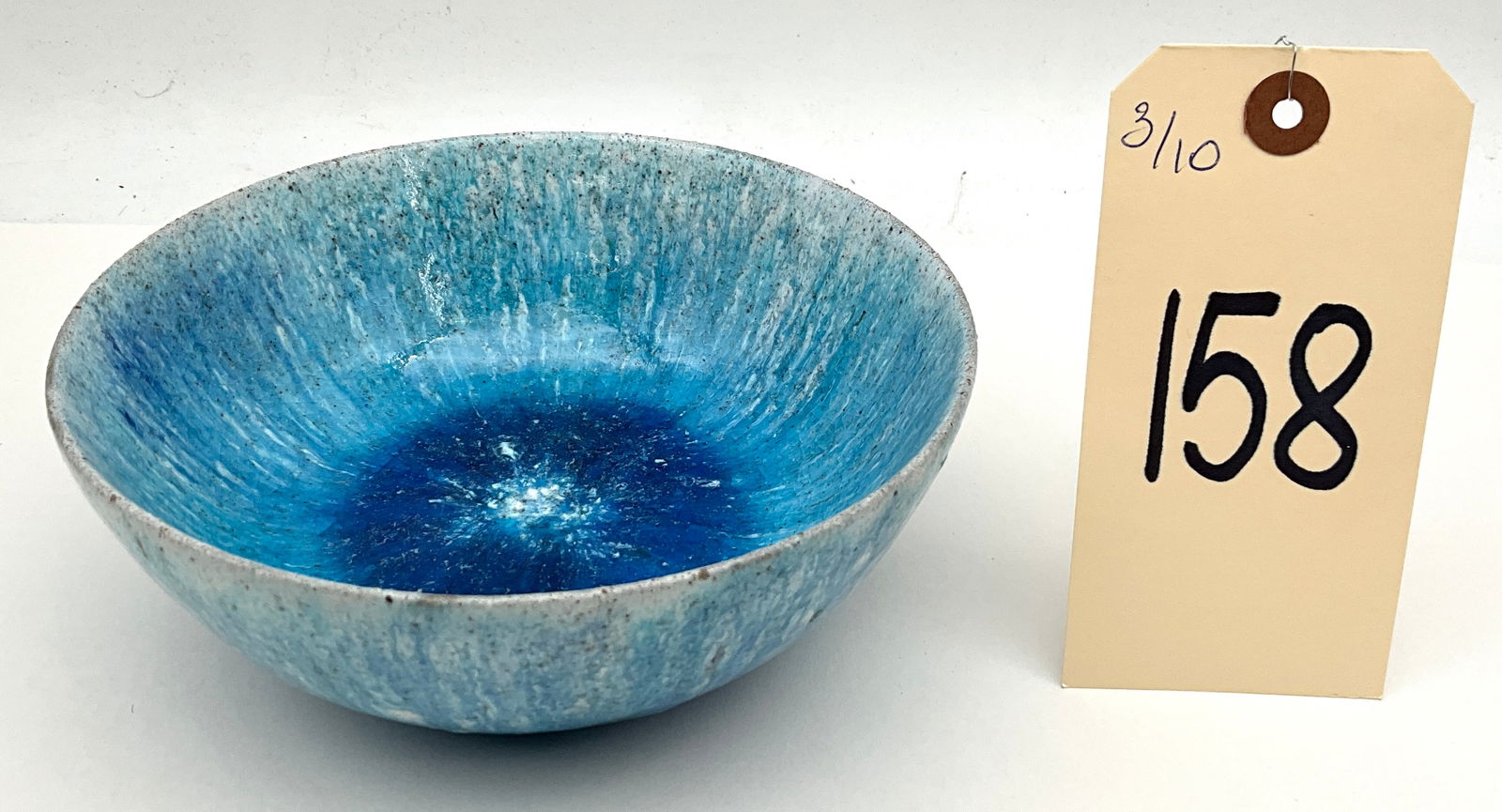 Marcello Fantoni for Raymor Mid-Century Modern Italian Ceramic Bowl: This Mid-Century Modern Italian ceramic bowl by Marcello Fantoni features a vibrant multi-tonal blue glaze with a textured radiating pattern transitioning from cobalt to mottled turquoise. The vessel