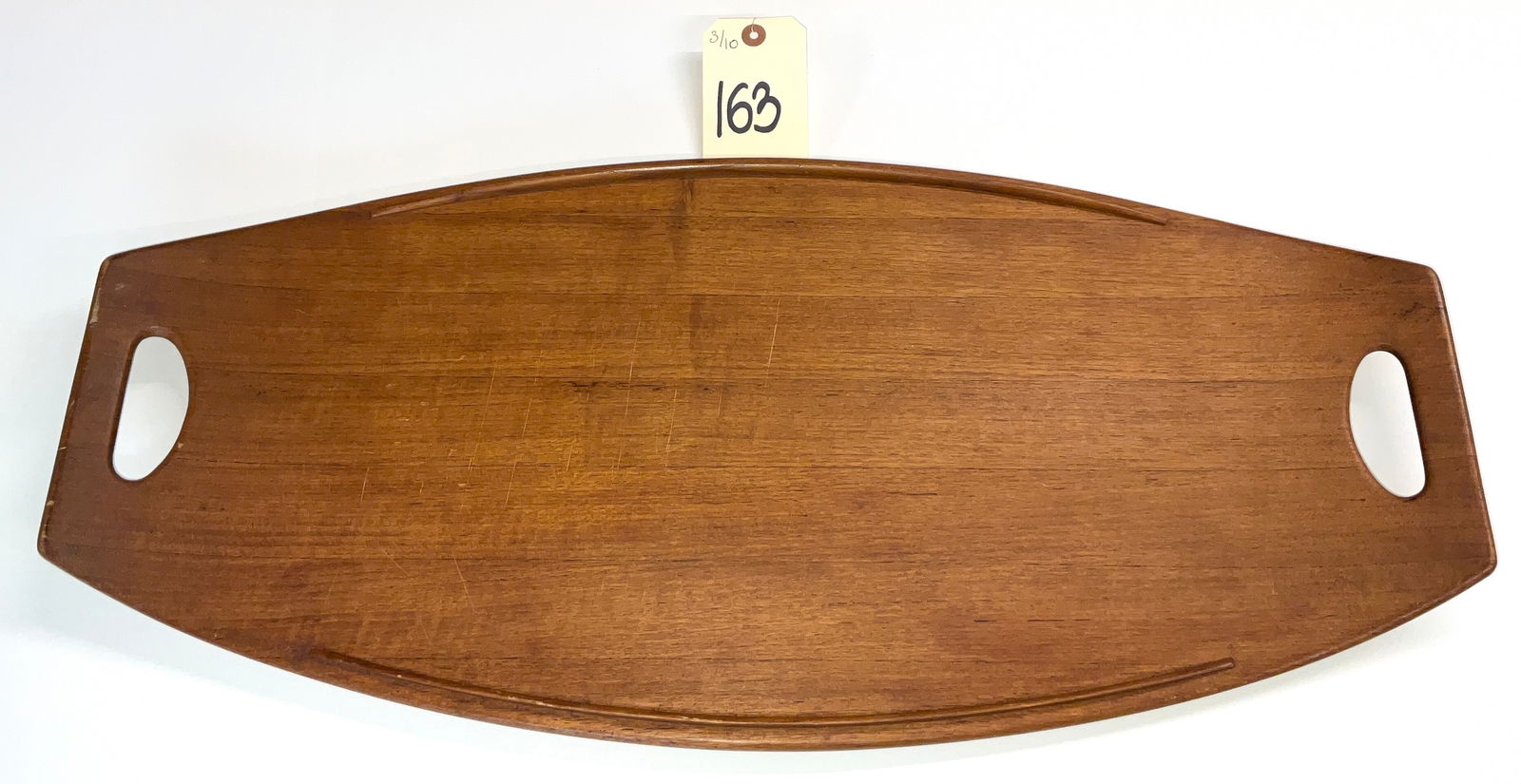 Jens Quistgaard for Dansk Teak Surfboard Serving Tray, Mid-Century Modern: This Mid-Century Modern serving tray was designed by Jens Quistgaard for Dansk and features an elegant, elongated surfboard silhouette. Crafted from staved teak, the piece includes integral carved han