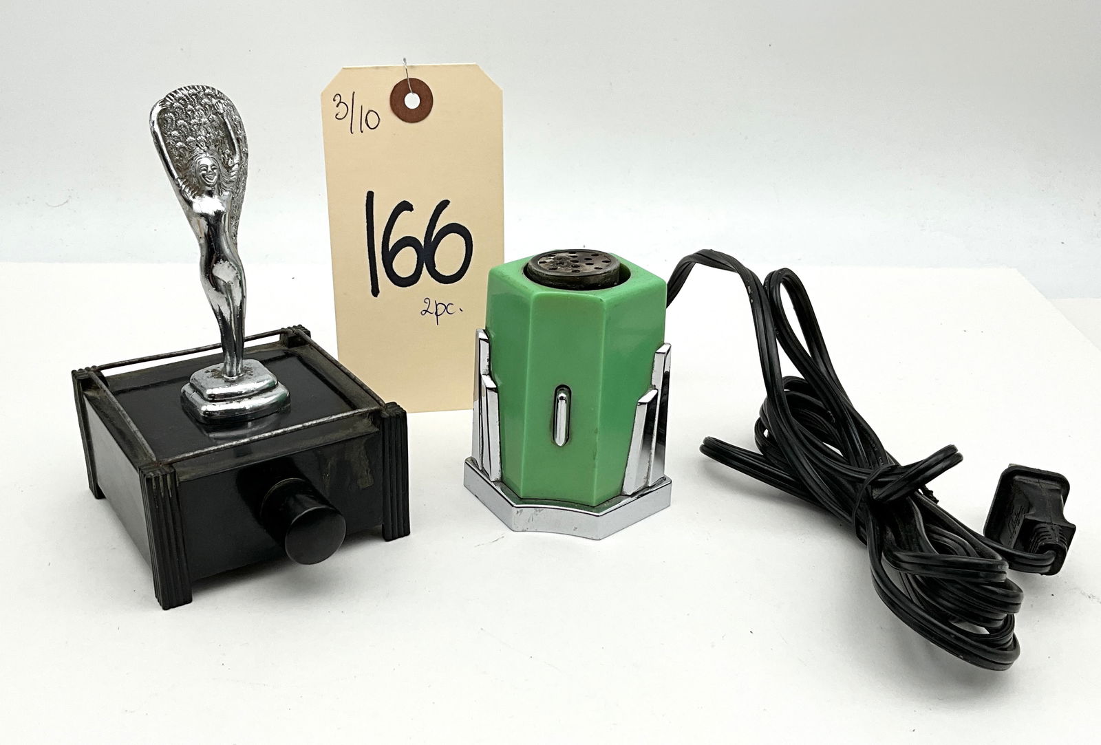 Parker of London and Geo. L. Mesker and Co., Vitrolite and Bakelite, Table Lighters: This lot features a Parker of London Silent Flame touch-tip lighter with a chrome-plated female mascot on a black Bakelite base and its original striking wand. It is paired with a Geo. L. Mesker and C