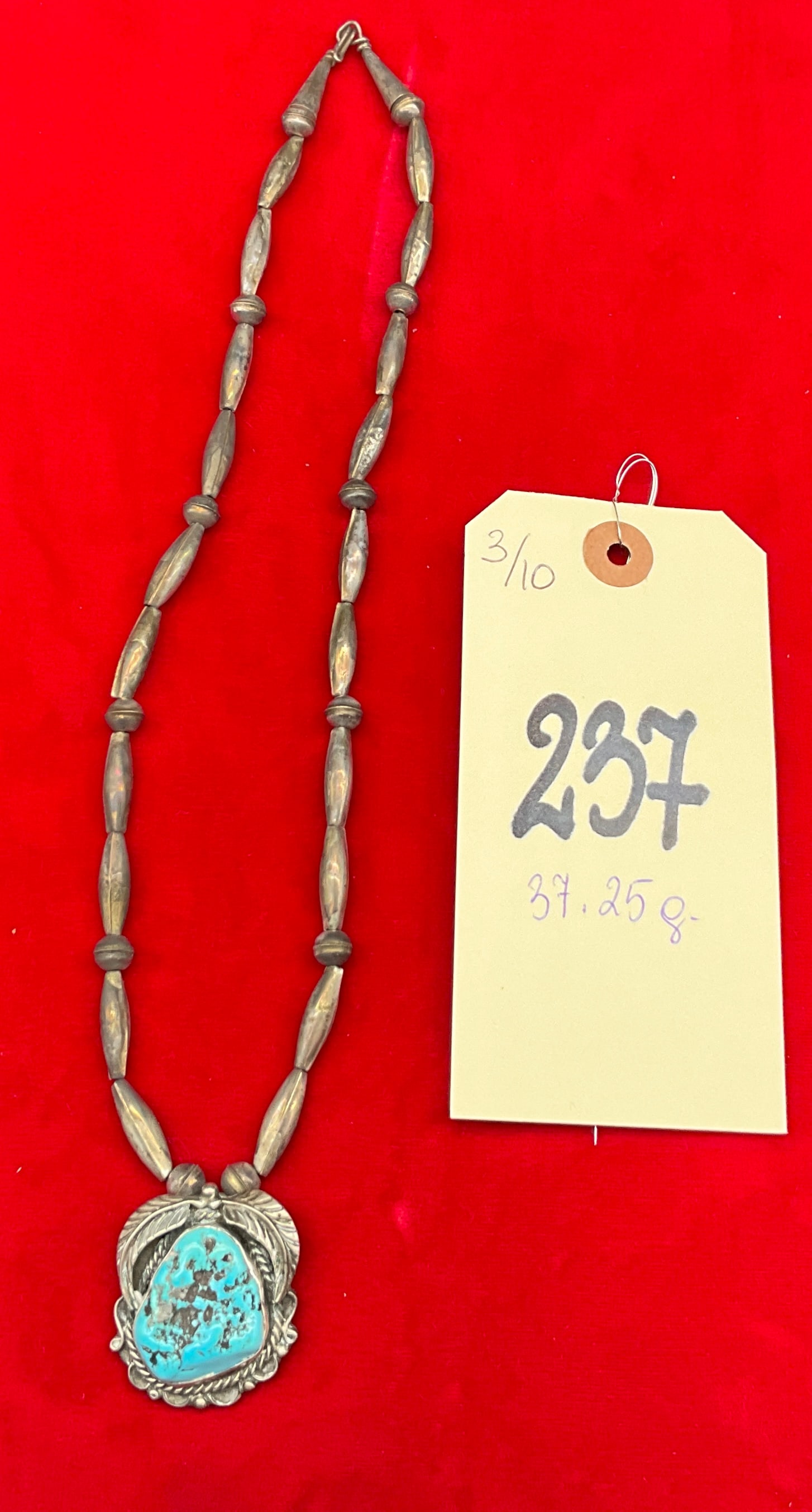 Navajo Sterling Silver Turquoise Pendant Necklace, Begay: This Navajo necklace features a large, freeform pendant with a stone that appears to be turquoise with a dark matrix, bezel-set in what appears to be sterling silver. The pendant is decorated with app