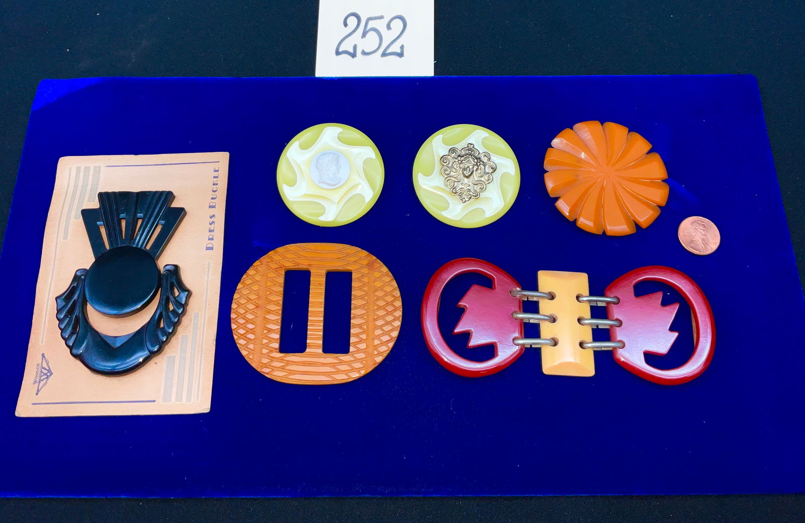 Vintage Bakelite and Celluloid Accessory Collection: This collection features a variety of early plastic accessories, including two yellow swirling brooches attributed to S. Schiller, one set with a molded cameo and the other with a gold-tone