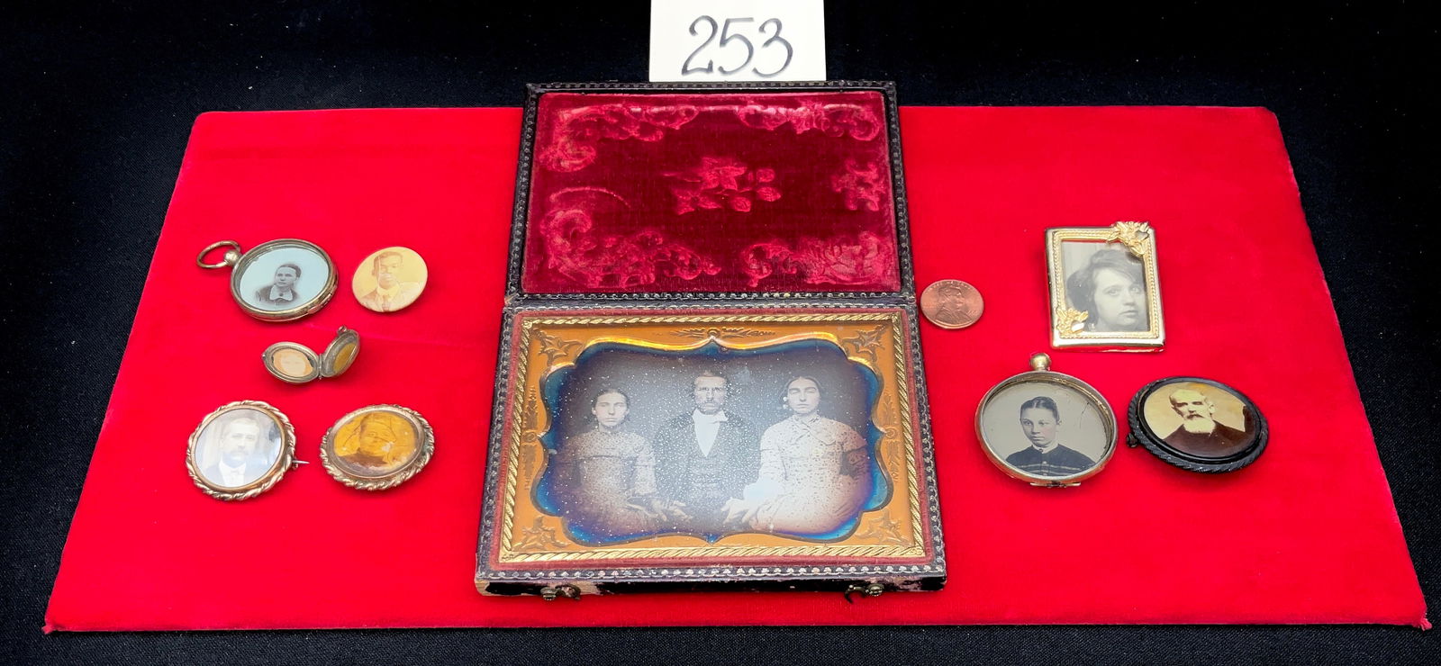 Antique Portrait Jewelry and Cased Ambrotype in Embossed Leather and Thermoplastic Union Case: This collection features a mid-19th-century Civil War era cased ambrotype depicting three figures housed in an embossed leather and wood case with a velvet-lined interior. The assortment includes
