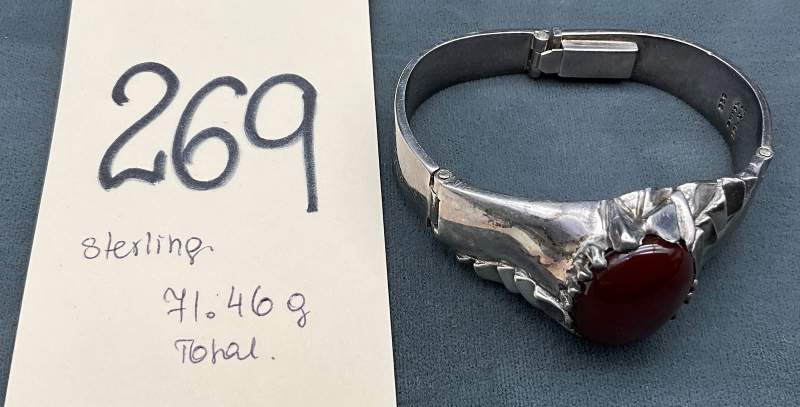 Mexican Sterling Silver Modernist Hinged Bangle with Carnelian: This Taxco-made sterling silver hinged bangle features a large reddish-brown cabochon that appears to be carnelian set within a sculptural sawtooth bezel. The modernist design includes geometric eleme