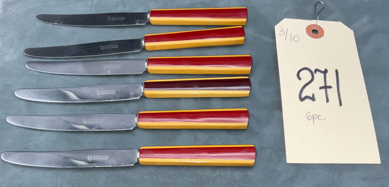 Stainless Steel Rostfrei Solingen Table Knife Set with Art Deco Bakelite Handles: This set of six table knives features stainless steel blades paired with vibrant two-tone Art Deco style handles. The faceted, tapered handles are constructed from red and butterscotch yellow Bakelite