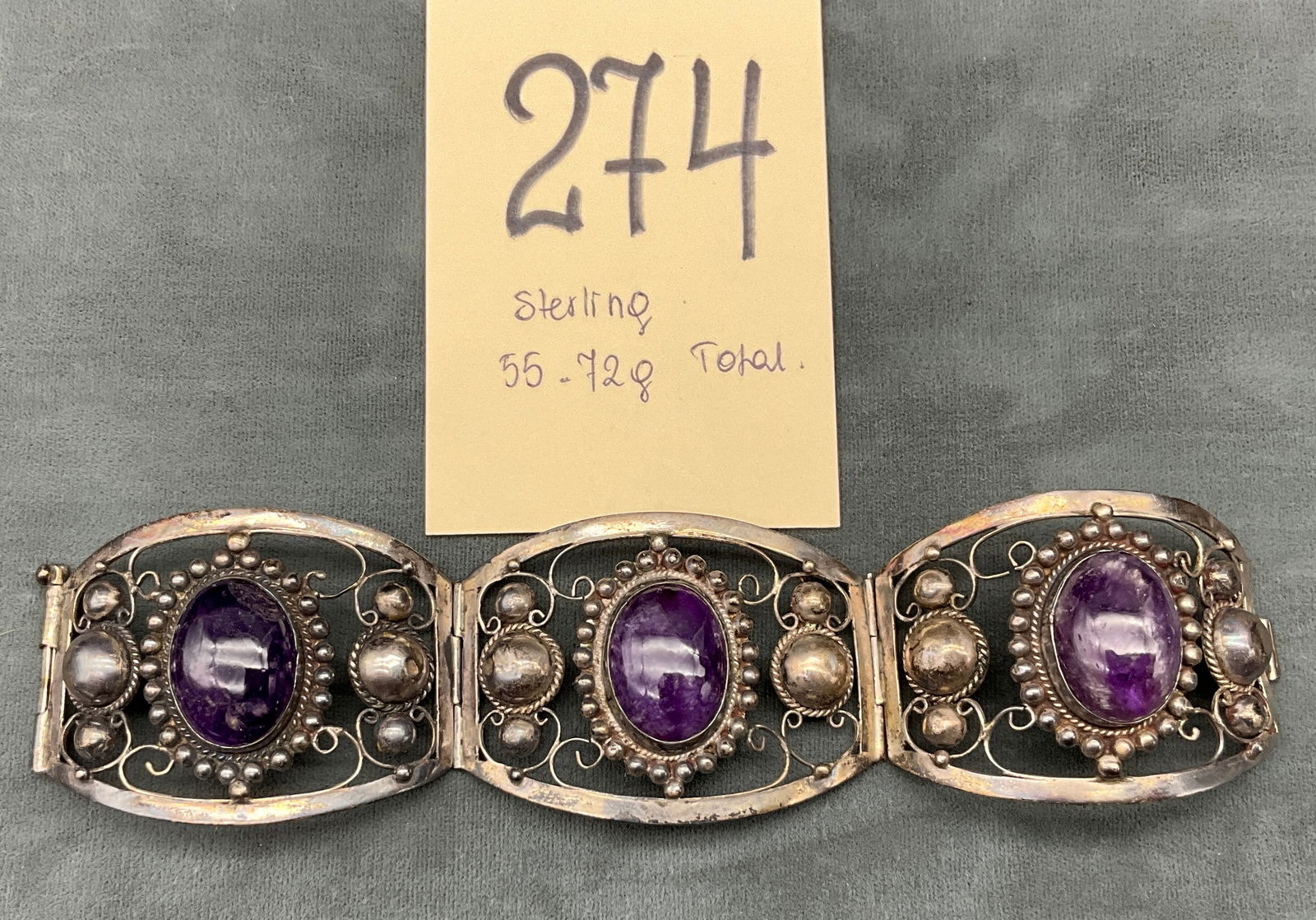 Mexican Amethyst and Sterling Silver Triple-Panel Bracelet: This vintage Mexican artisan sterling bracelet features three wide, articulated panels set with large oval amethyst cabochons. Each stone is framed by intricate silver wirework filigree, beaded bezels