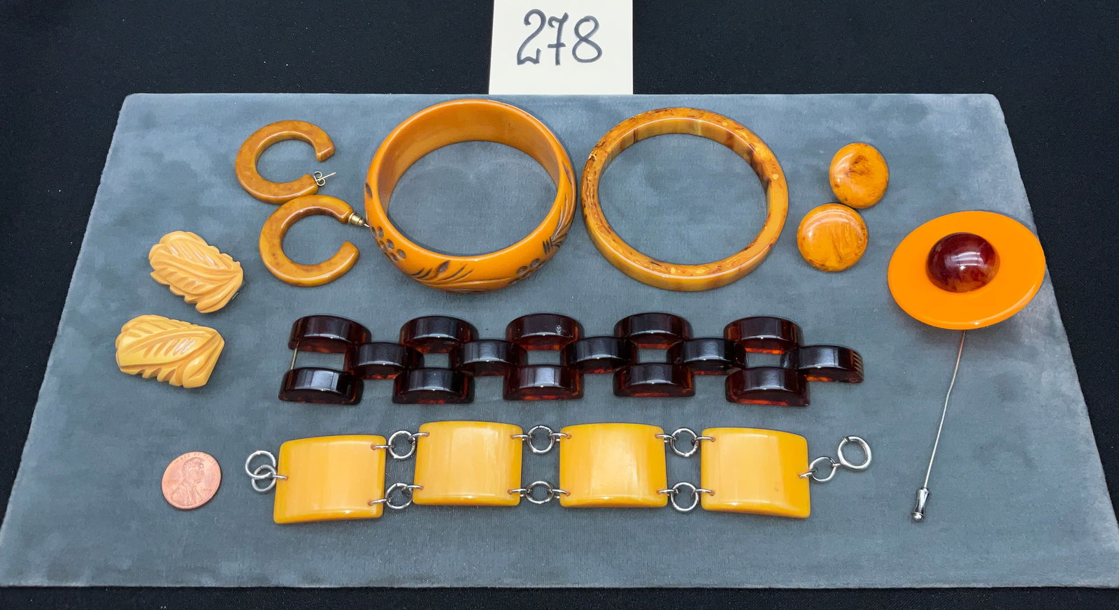 Silver-Tone Base Metal, Geometric and Botanical Motif Vintage Bakelite Jewelry Collection: This collection of vintage Bakelite jewelry features a large geometric stick pin and a pair of intricately carved botanical leaf dress clips. The lot includes two bangles, one with deep floral carving