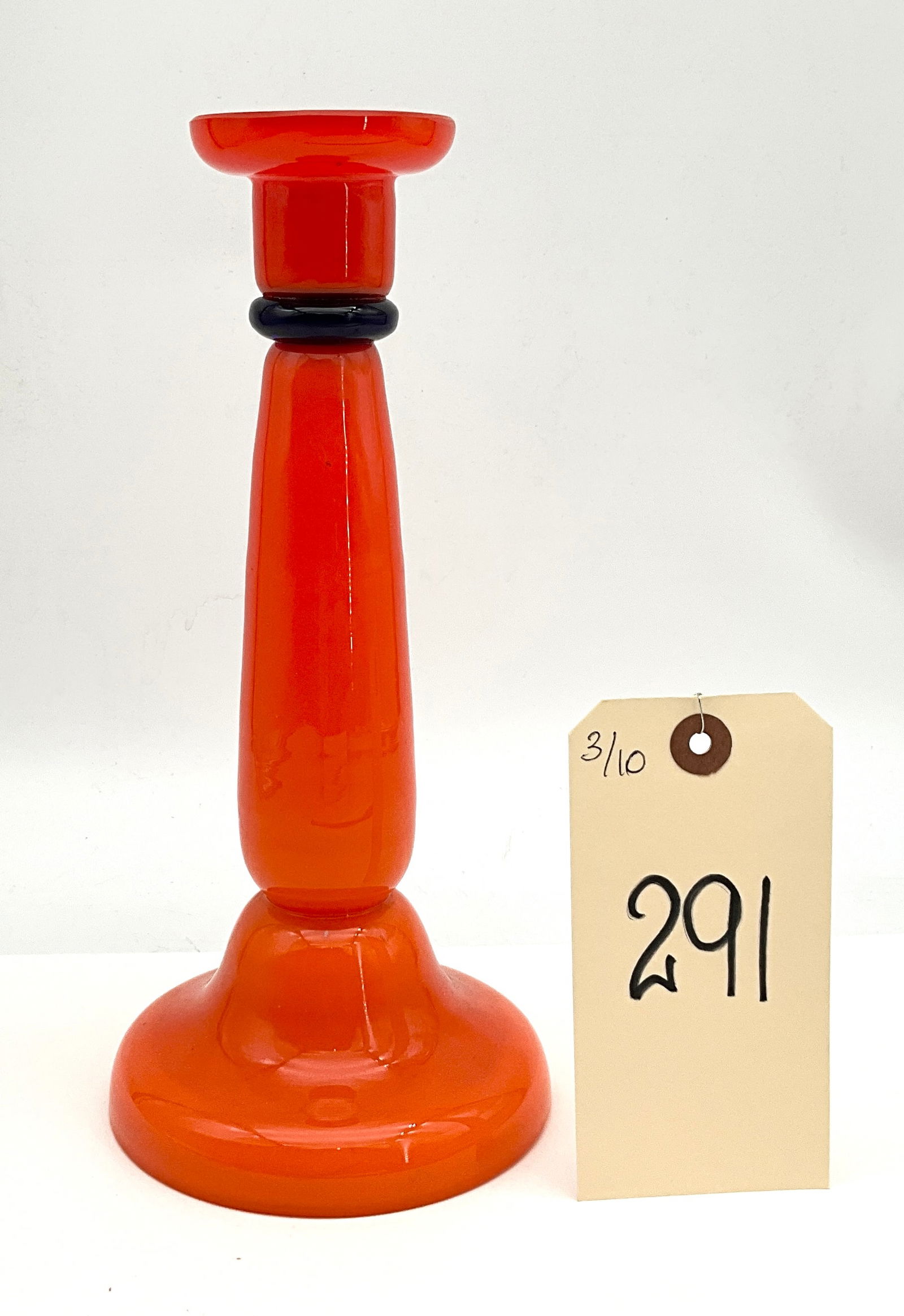 Czech Art Deco Tango Glass Candlestick Holder: This Art Deco period candlestick holder is a striking example of Czech Tango glass, featuring a vibrant opaque orange body. The piece is accented by a contrasting dark black glass ring at the neck, a