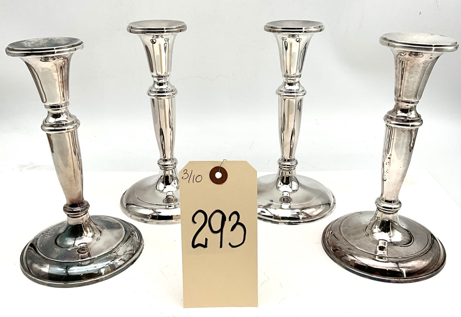 Set of Four Classical Baluster-Form Weighted Silver Plated Candlesticks: This set of four silver plated candlesticks features a classical baluster-form stem and stepped circular bases. Each piece is of weighted construction, a design characteristic common in mid-20th-centu