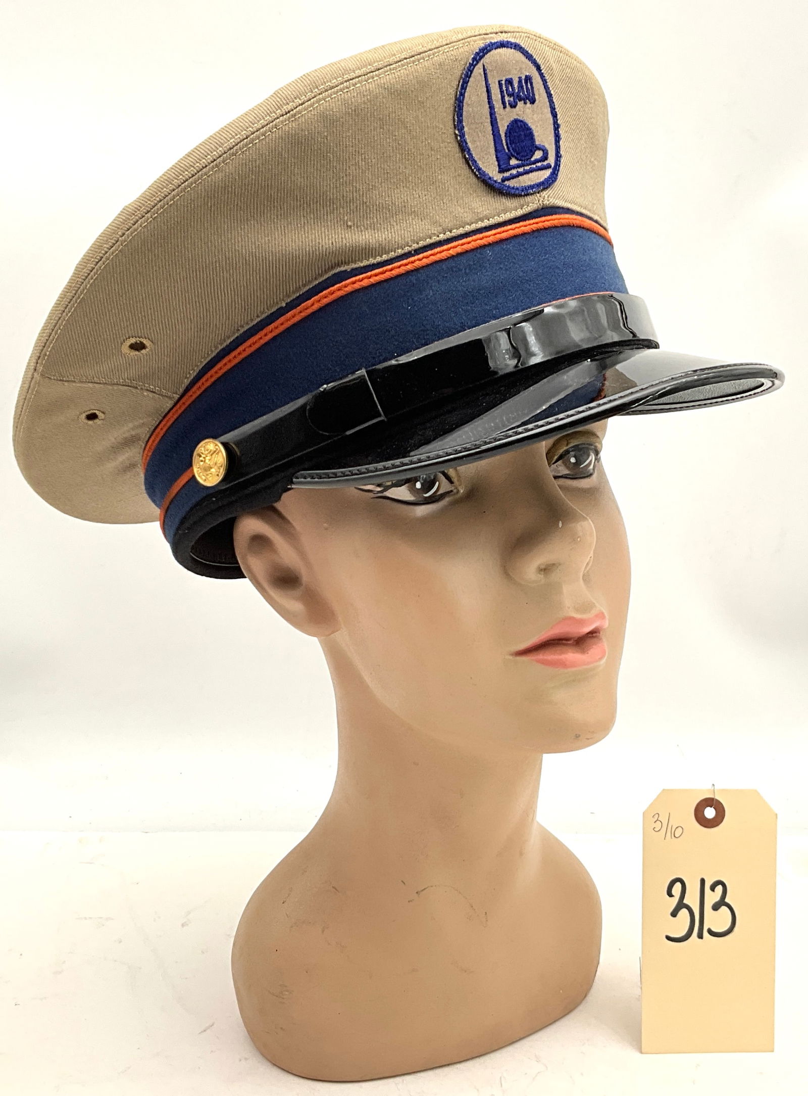 Bancroft 1940 New York World's Fair Commemorative Service Cap: This commemorative service cap was produced by Bancroft Military Caps for the 1940 New York World's Fair. The construction includes a tan twill crown and a dark blue band with orange piping, secured b