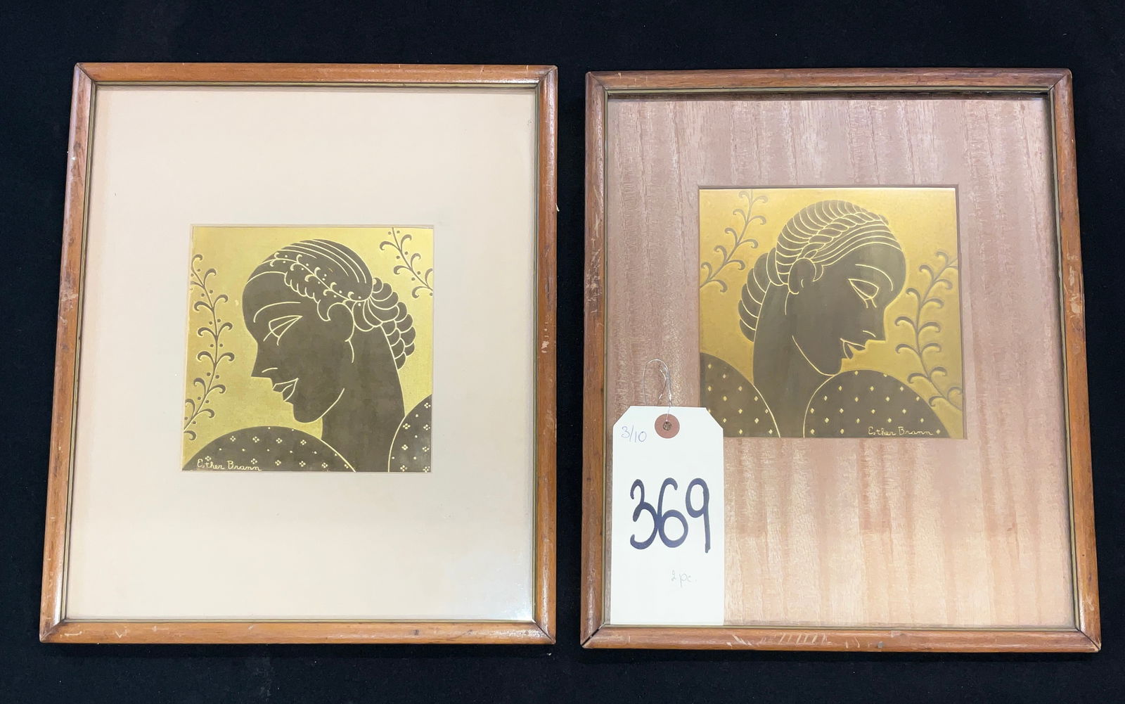 Esther Brann, A Pair of Art Deco Style Etched Metal Plaques, Female Profiles: This pair of Art Deco style plaques features stylized female profiles rendered in etched gold-tone metal with dark recessed detailing. Each piece is signed by the artist Esther Brann and depicts a wom