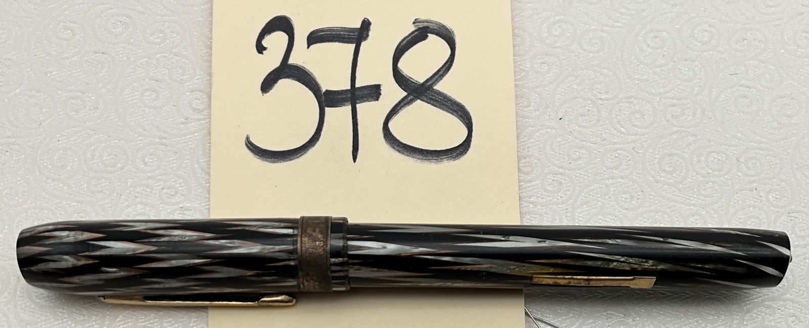 Imperial Indian Pattern Fountain Pen 14k tip: This Imperial fountain pen features a celluloid body in the Indian pattern, characterized by a chevron decoration of black, pearlescent gray, and copper tones. The 14K gold nib is stamped Imperial / 1