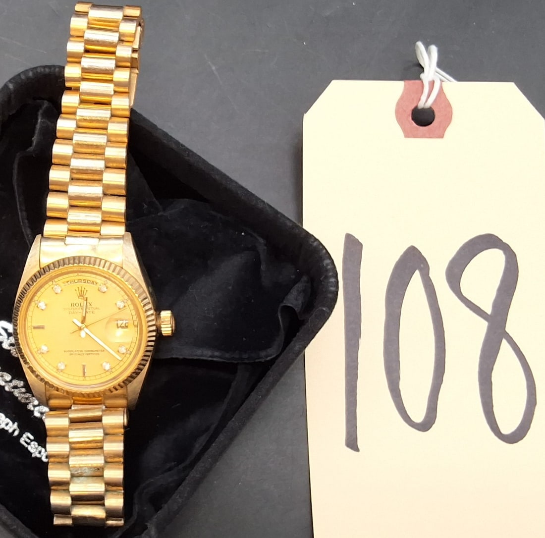 Imitation Rolex Day-Date gold tone watch: Imitation Rolex Day-Date gold tone watch Condition All property is sold in "as is" condition and all sales are final. Teel Auctions and its consignor make no representations or warranties, express or 