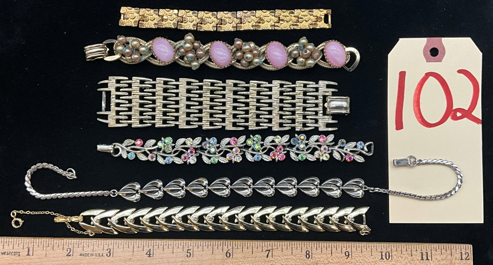 A Collection of Six Vintage Mid-Century Costume Jewelry Bracelets: This group of six bracelets features mid-century styles including signed pieces by makers Coro, Lisner, and Lustern alongside unsigned gold-tone links. The collection includes a wide silver-tone mesh