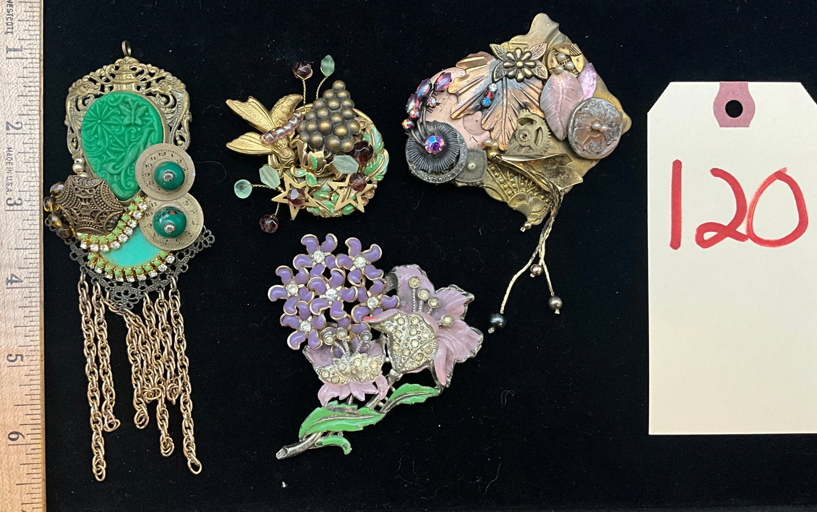 An Assortment of Vintage and Contemporary Brooches Including Coro and Sarah Jane: This collection features a vintage Coro floral brooch with purple enamel and rhinestone accents alongside three contemporary mixed-media assemblage pieces. One circular botanical brooch is signed