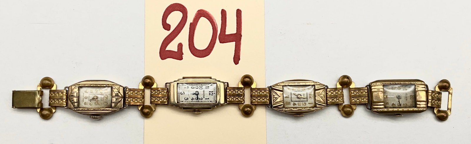 A Group of Four Art Deco Ladies Wristwatches Configured as a Bracelet: This vintage assembly features a group of four ladies manual-wind wristwatches by Hamilton, Elgin, and a Swiss manufacturer joined to form a multi-dial bracelet. The watch cases include a Hamilton