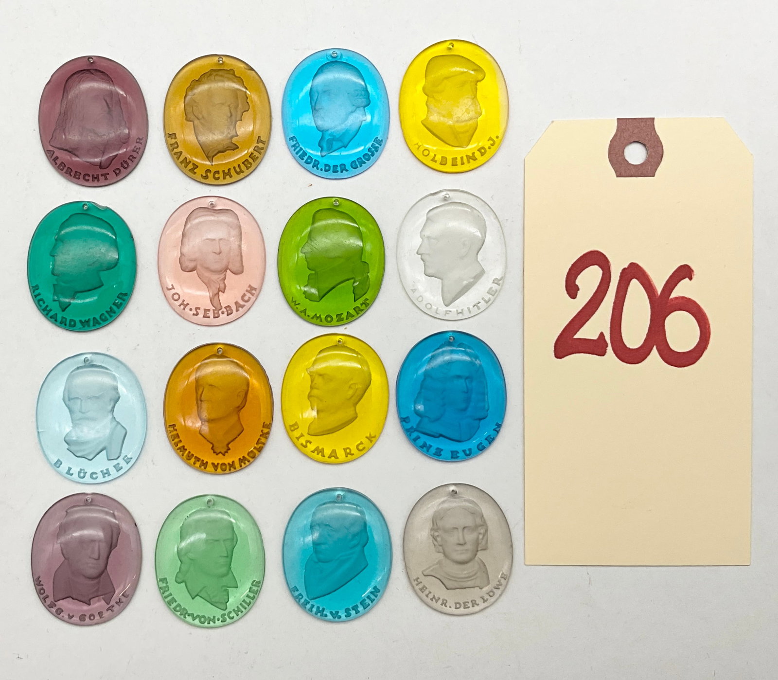 A Collection of Sixteen 1942 Winterhilfswerk Trolitul Donation Tokens: This collection includes sixteen translucent Trolitul plastic medallions from the 1942 Winterhilfswerk series titled K�pfe ber�hmter Deutscher. Each oval token features a high-relief