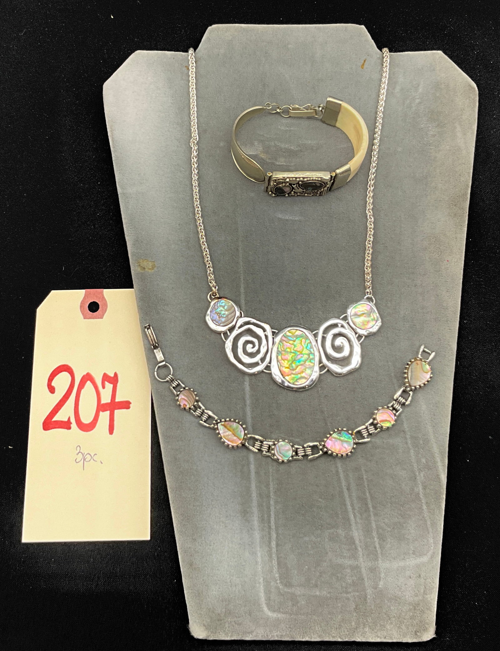 Three Abalone Shell and Silver-Tone Metal Jewelry Pieces: This three-piece collection includes a bib-style necklace, a matching link bracelet, and a wide hinged cuff bracelet, all featuring iridescent abalone shell cabochons. The necklace and link bracelet