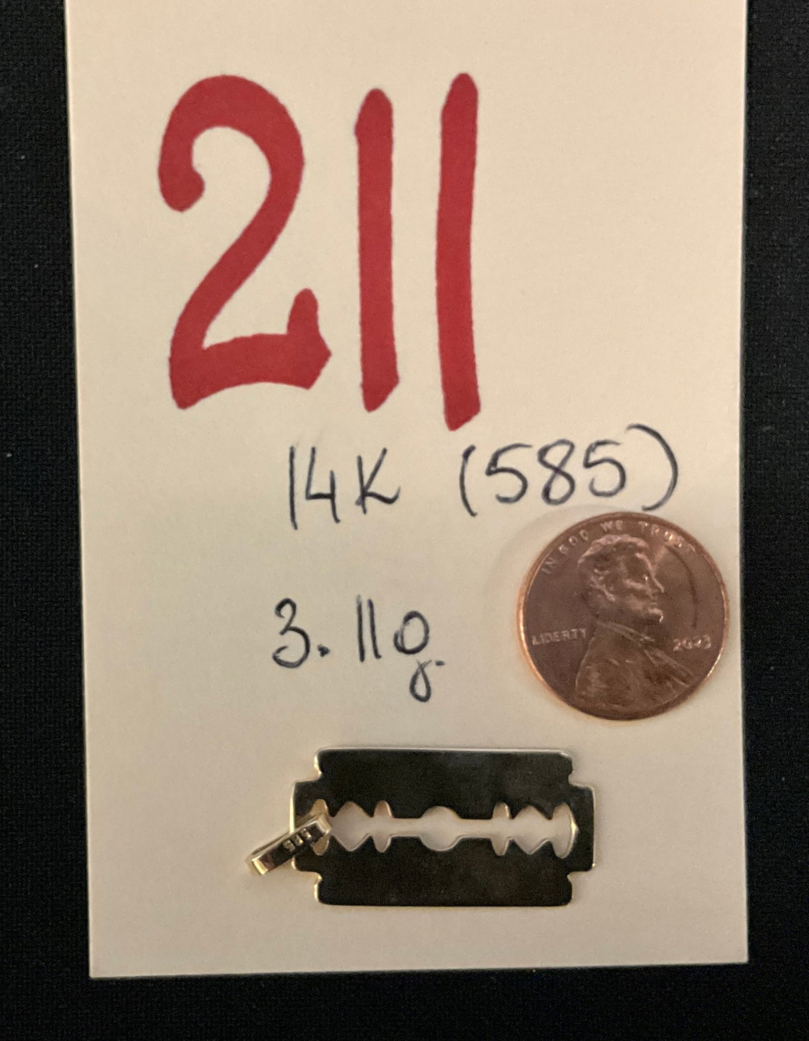 14 Karat Yellow Gold Razor Blade Pendant: This novelty 80s vintage style pendant is crafted from 14 karat yellow gold in the form of a classic double-edge razor blade. The piece features a high-polish finish with characteristic central